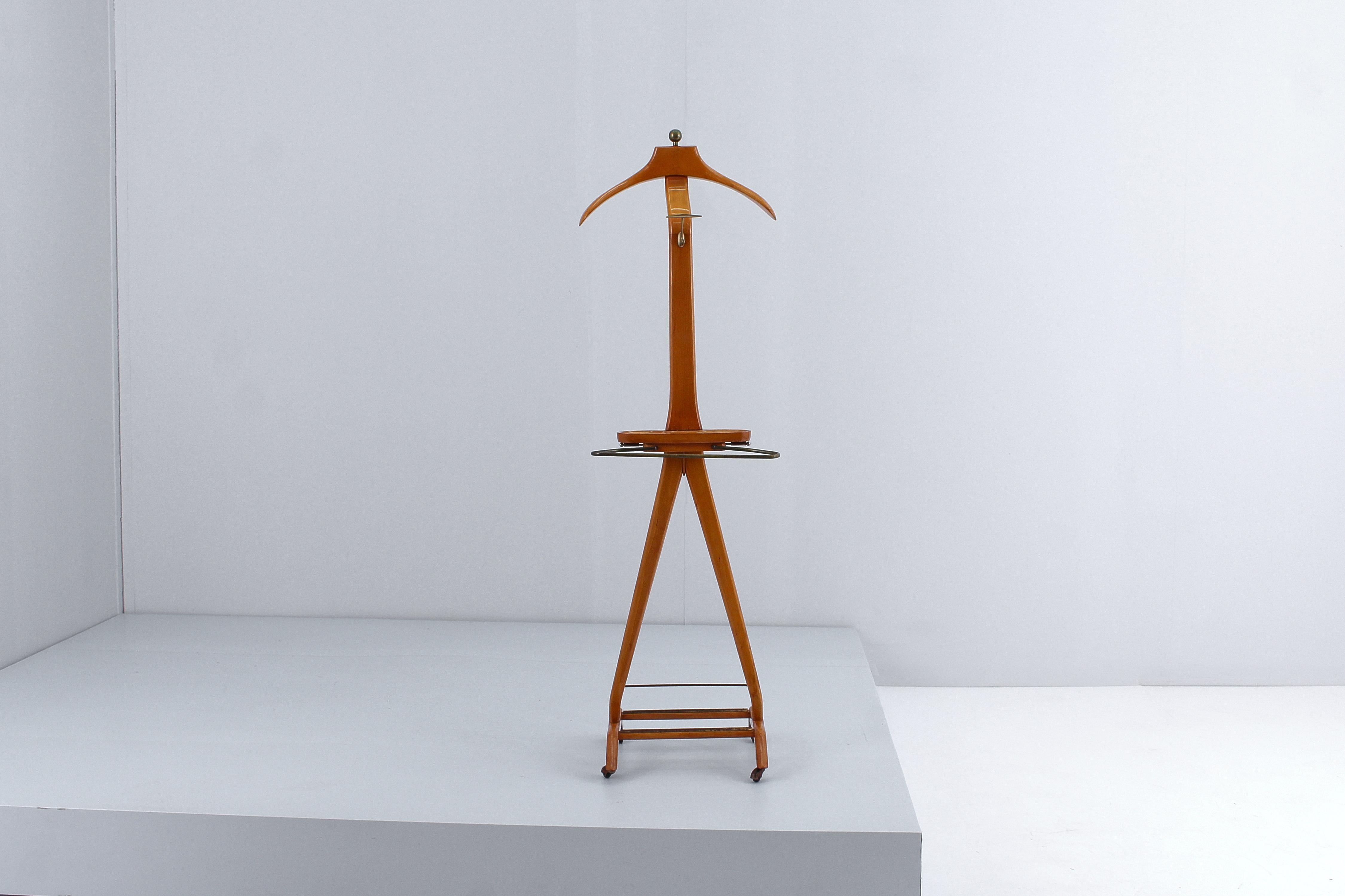 Elegant valet stand with pull-out rods, equipped with jacket and trouser holder, brass hook, shoe rack and a cufflink or jewelery holder, in molded wood. Designed by Ico Parisi for Fratelli Reguitti, Italian manifacture in 60s. Restored. Hot stamped