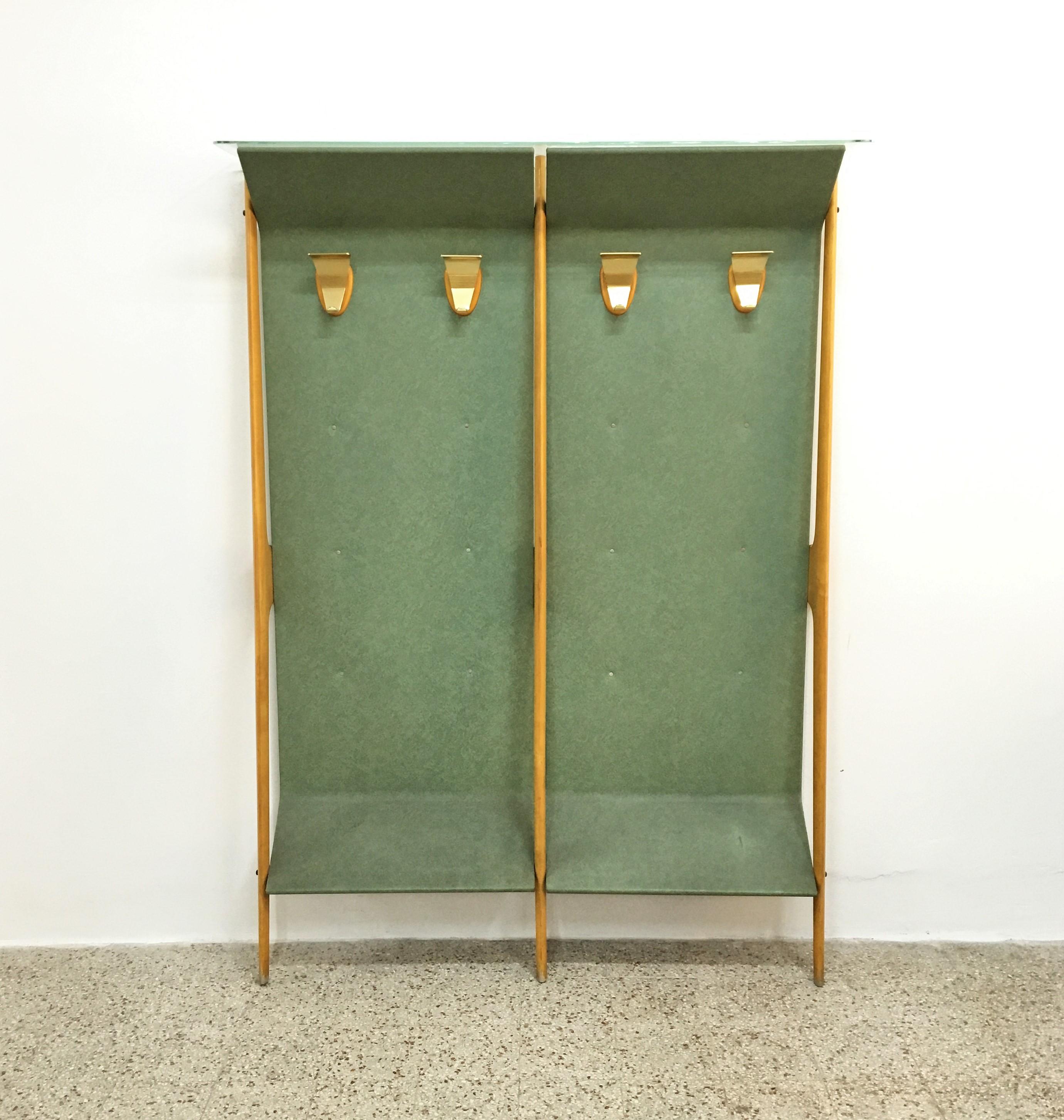 Original and beautiful wall hanger, with geometric shapes in light wood with panel covered in green skai, with golden metal elements, and glass shelf - hatbox on the top.
In the style of Ico Parisi, Cantù production in the 1950s, Italy.
Good