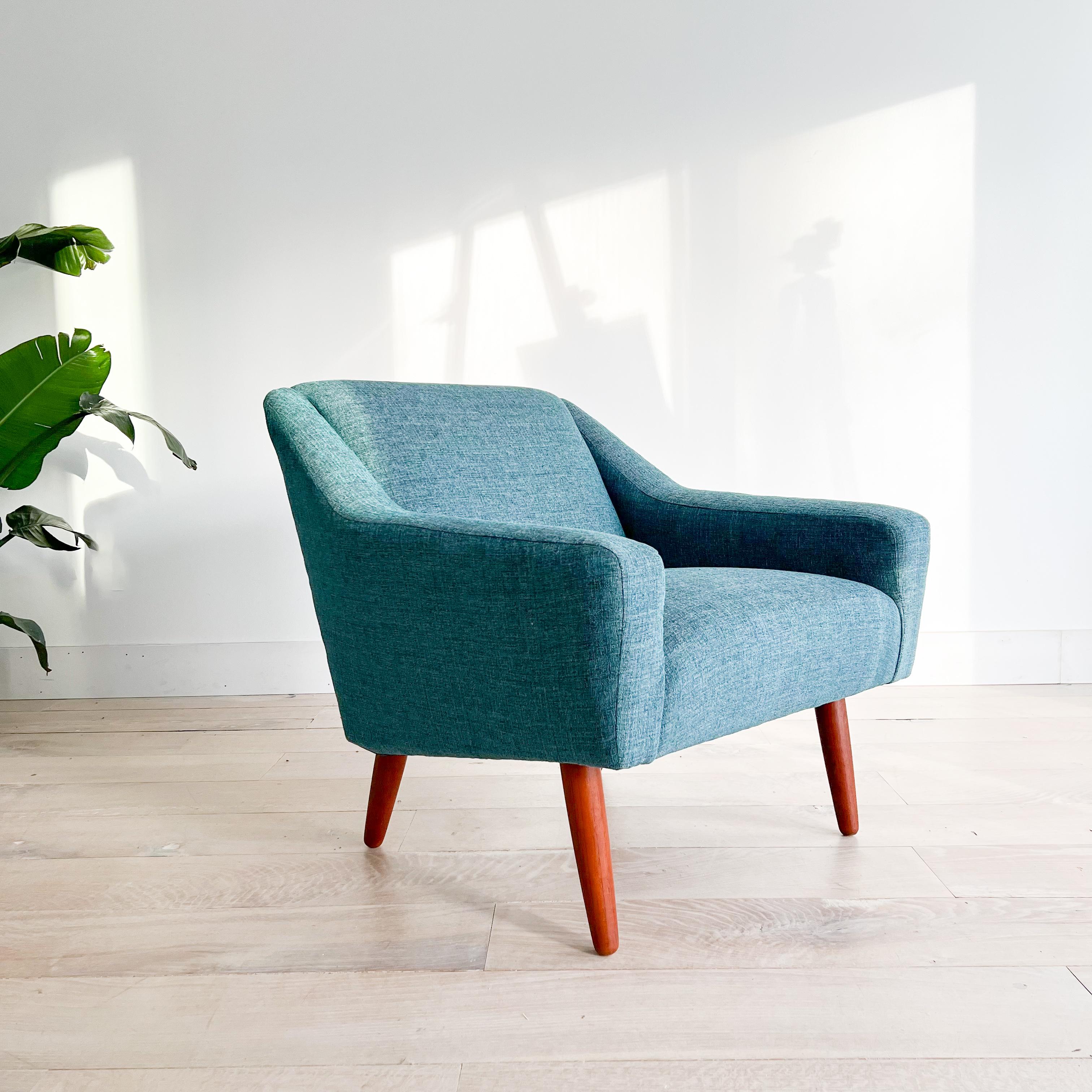 Introducing a mid-century modern lounge chair by Illum Wikkelso. Newly upholstered in a tasteful teal fabric with fresh foam for optimal comfort. The chair, measuring 32 inches by 32 inches, boasts a comfortable seated height of 16.5 inches and an