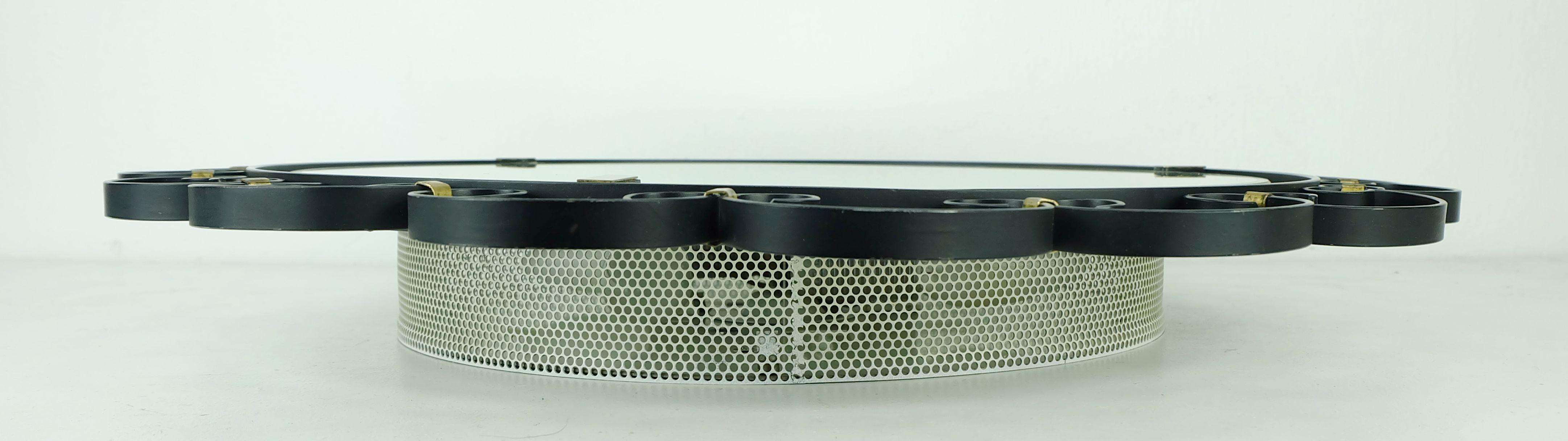 Très beau miroir mural rond éclairé des années 1960, fabriqué par Hillebrand. Le cadre est en métal noir mat et en laiton. Base laquée blanche avec cadre en maille. Peut contenir 4 ampoules E14.

Dimensions : Diamètre total 21 1/4