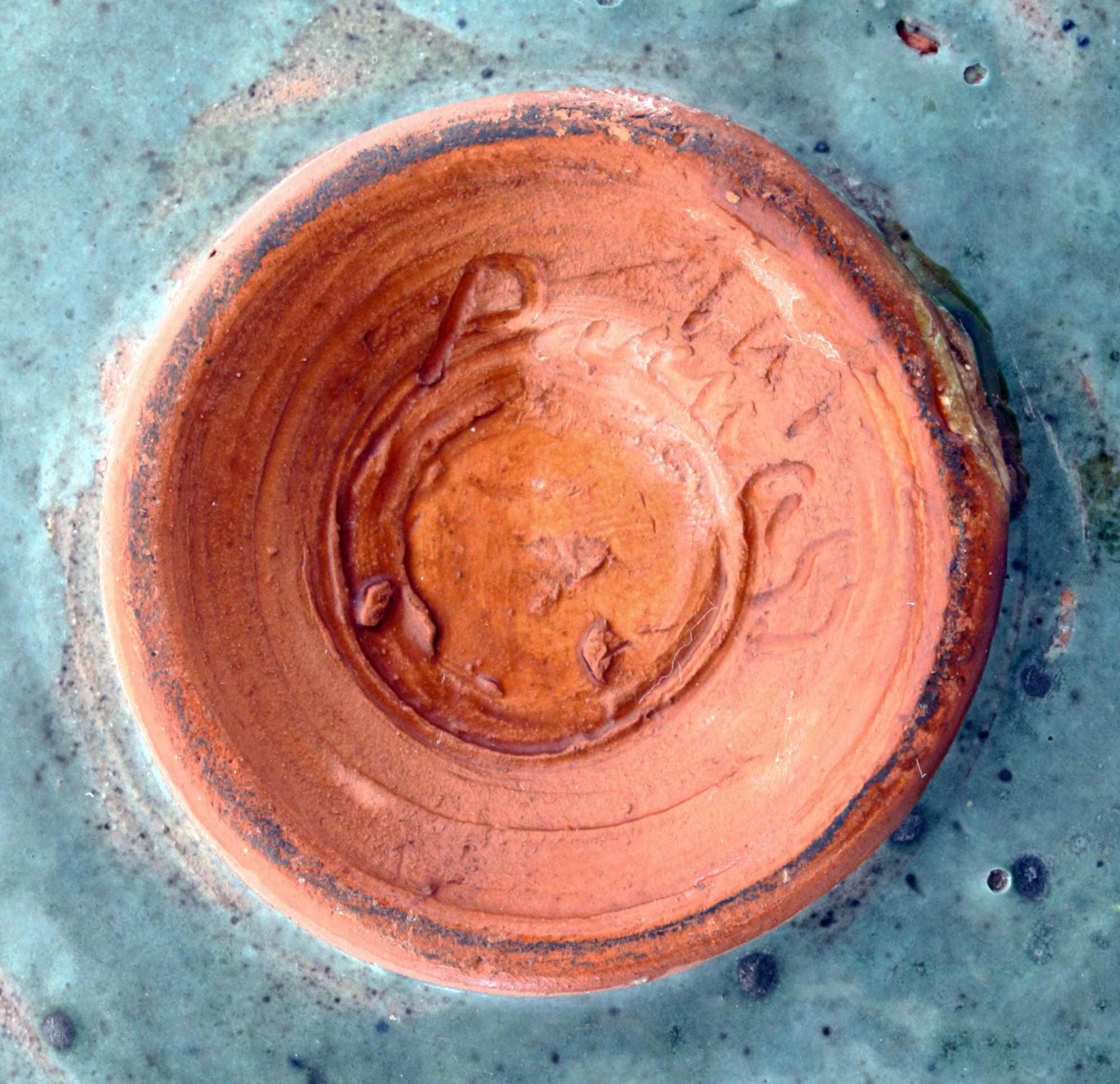 A good decorative hand painted vintage Studio Pottery dish with a fish swimming amidst weed believed to date from the midcentury. The rounded shallow dish is made in red clay standing on a narrow rounded foot and is hand decorated in lava textured