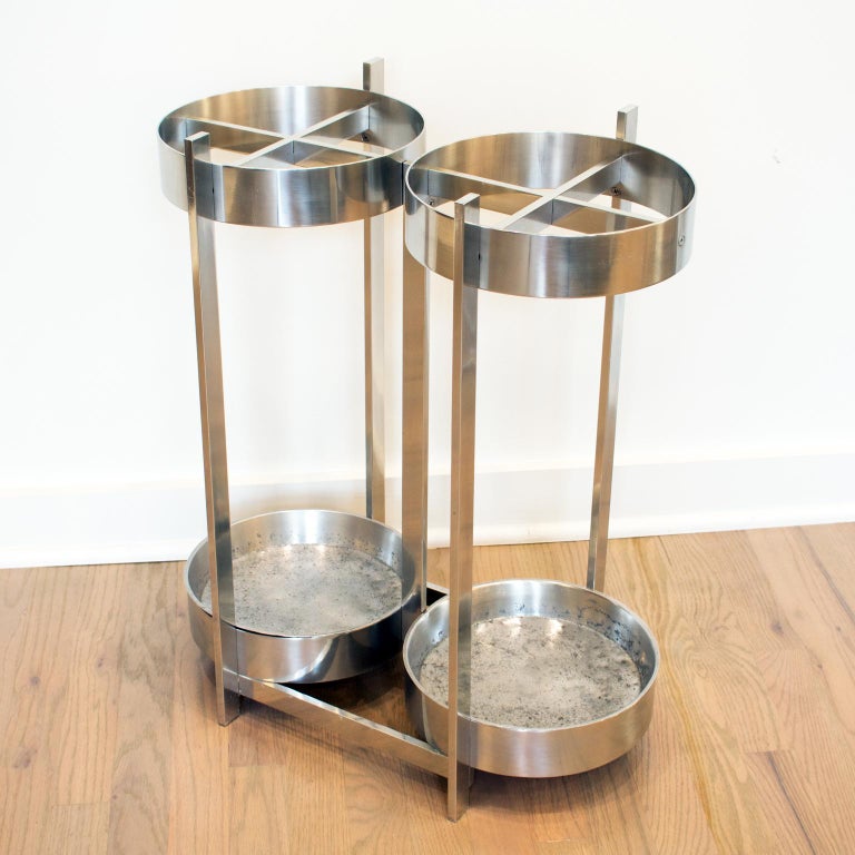 Elegant Mid-Century modernist aluminum umbrella stand, holder. Industrial Machine Age design with large double round shape and removable inserts. No visible maker's mark.
Measurements: 21 in. wide (53.5 cm) x 12 in. deep (30.5 cm) x 25 in. high (64