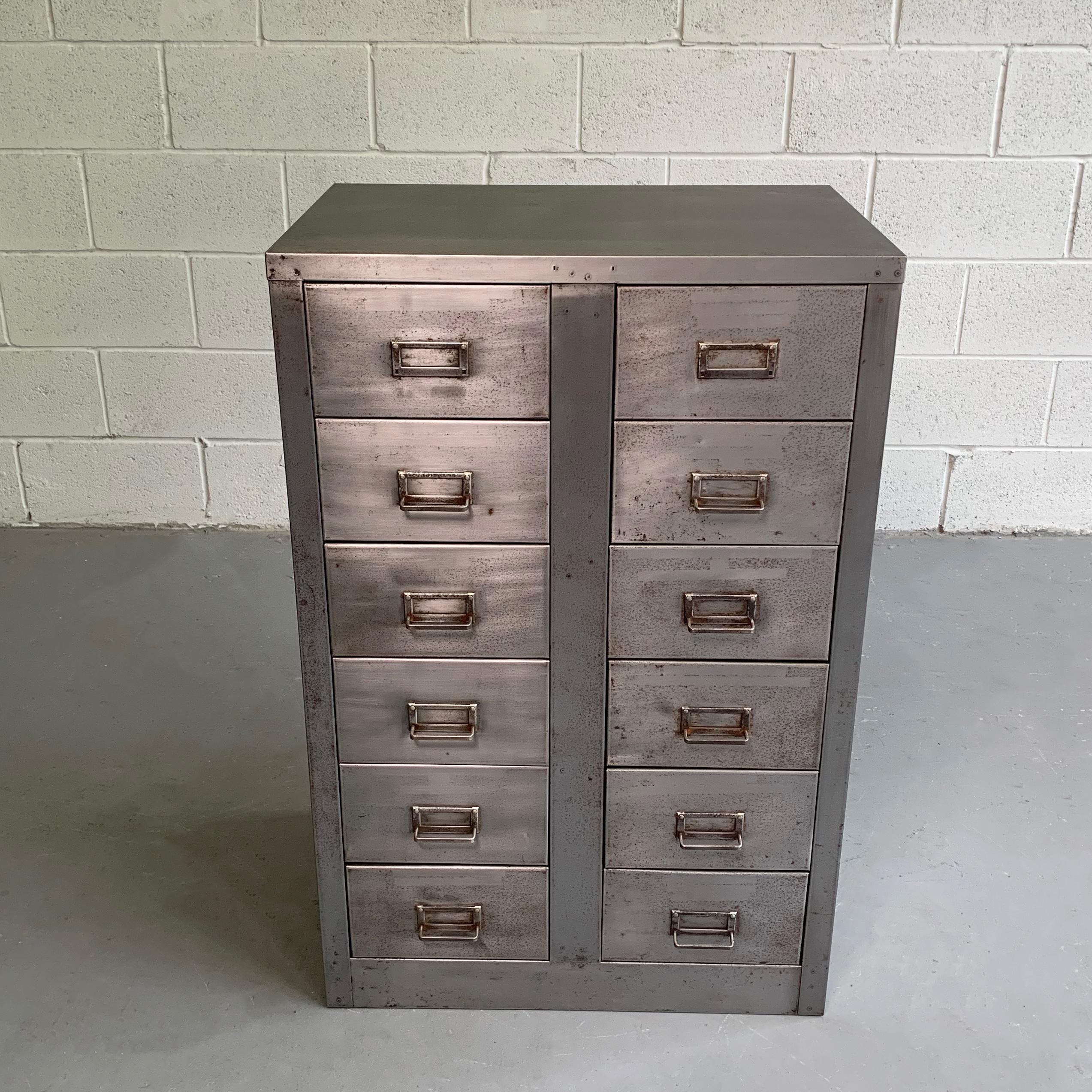 Midcentury, Industrial, 10 drawer, office filing cabinet features a brushed steel finish with brass label plate pulls. The drawers measure 5.25 inches, height 9.25, inches wide.