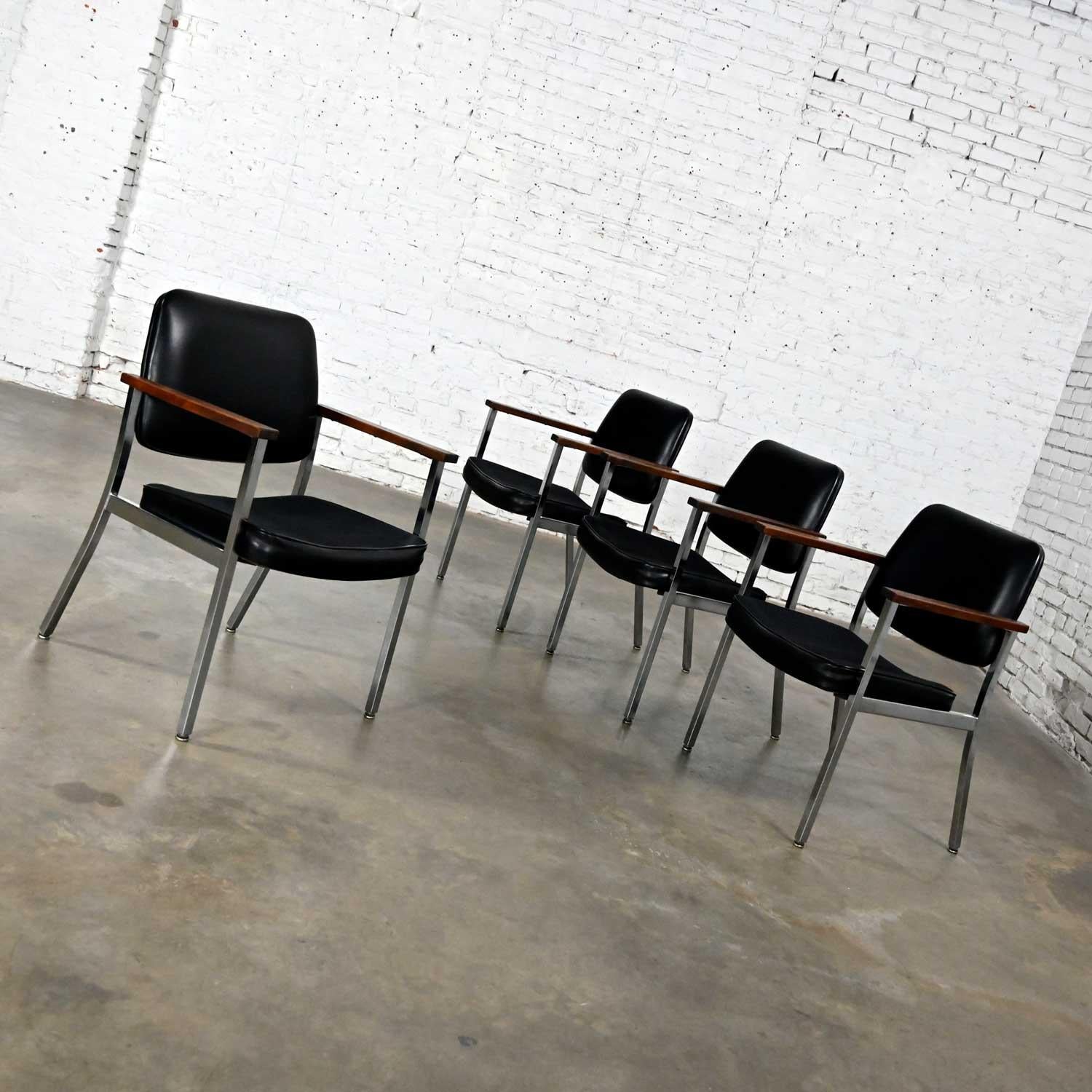 Wonderful mid-century Industrial set of 4 dining or office chairs comprised of chrome frames, black vinyl seats and backs, and wood arms by Superior Chaircraft. Beautiful condition, keeping in mind that these are vintage and not new so will have