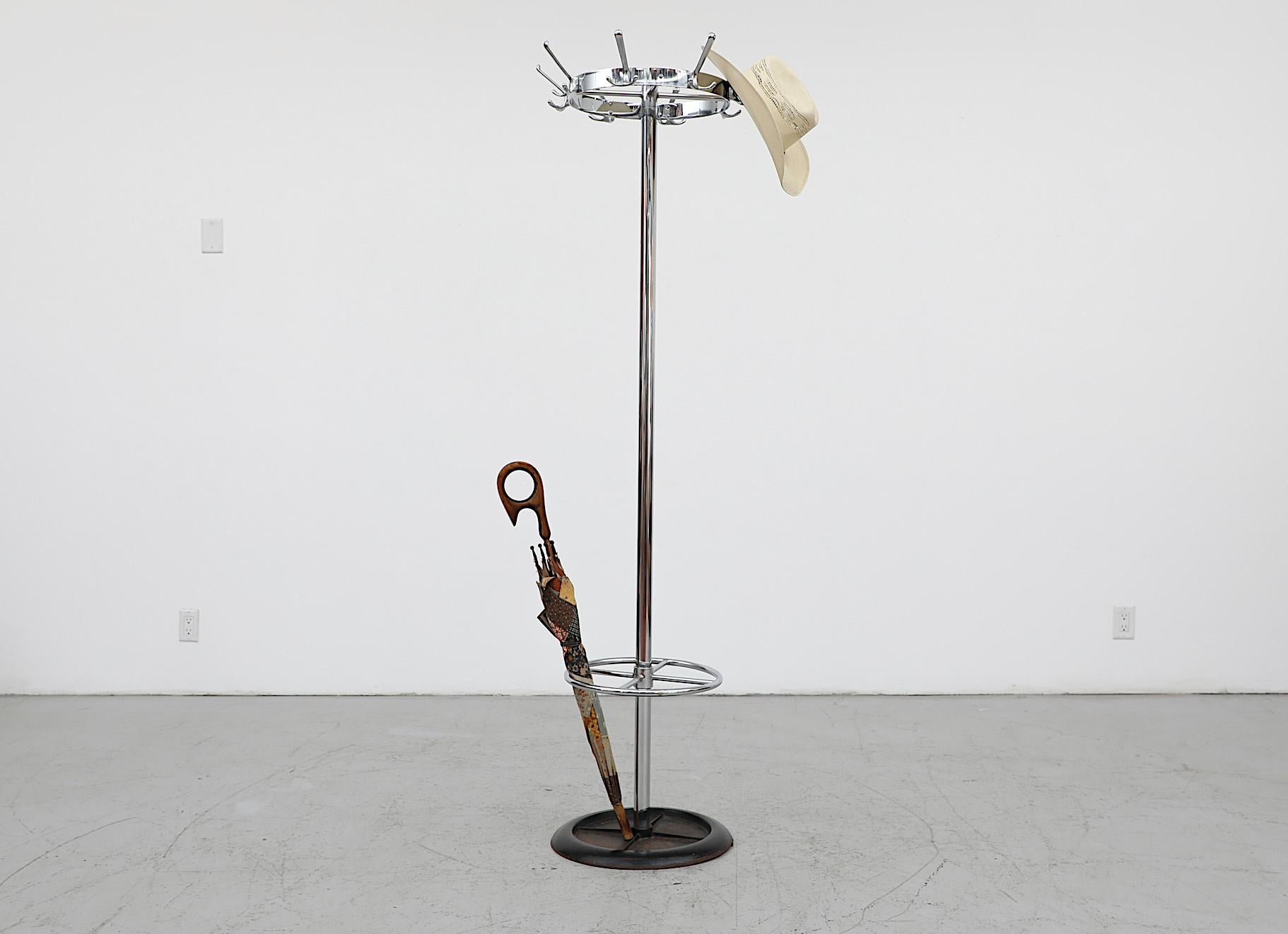Mid-Century standing industrial coat rack with spinning top, chrome post, cast aluminum hooks and heavy black enameled metal weighted base with ring for umbrellas. In original condition with visible wear and some base rust.