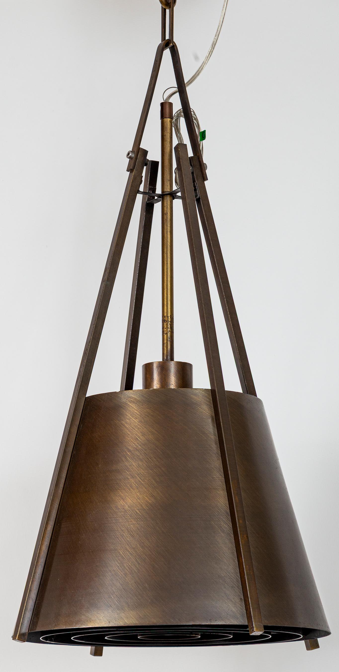 Un atractivo conjunto de lámparas colgantes vintage de latón y forma cónica de alta calidad, en acabado cepillado oscuro, con soportes angulares y difusores de rejilla de acero patinado a juego, que les confieren una estética industrial pero