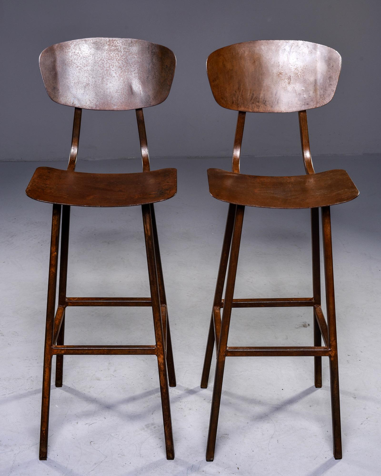 Sold individually, these circa 1940s bar height industrial stools were found in England and are made of welded iron and have a rusty brown colored finish. 

Measures: Seat height: 28.75 to 29”, seat depth: 11”, seat width: 14.75”.