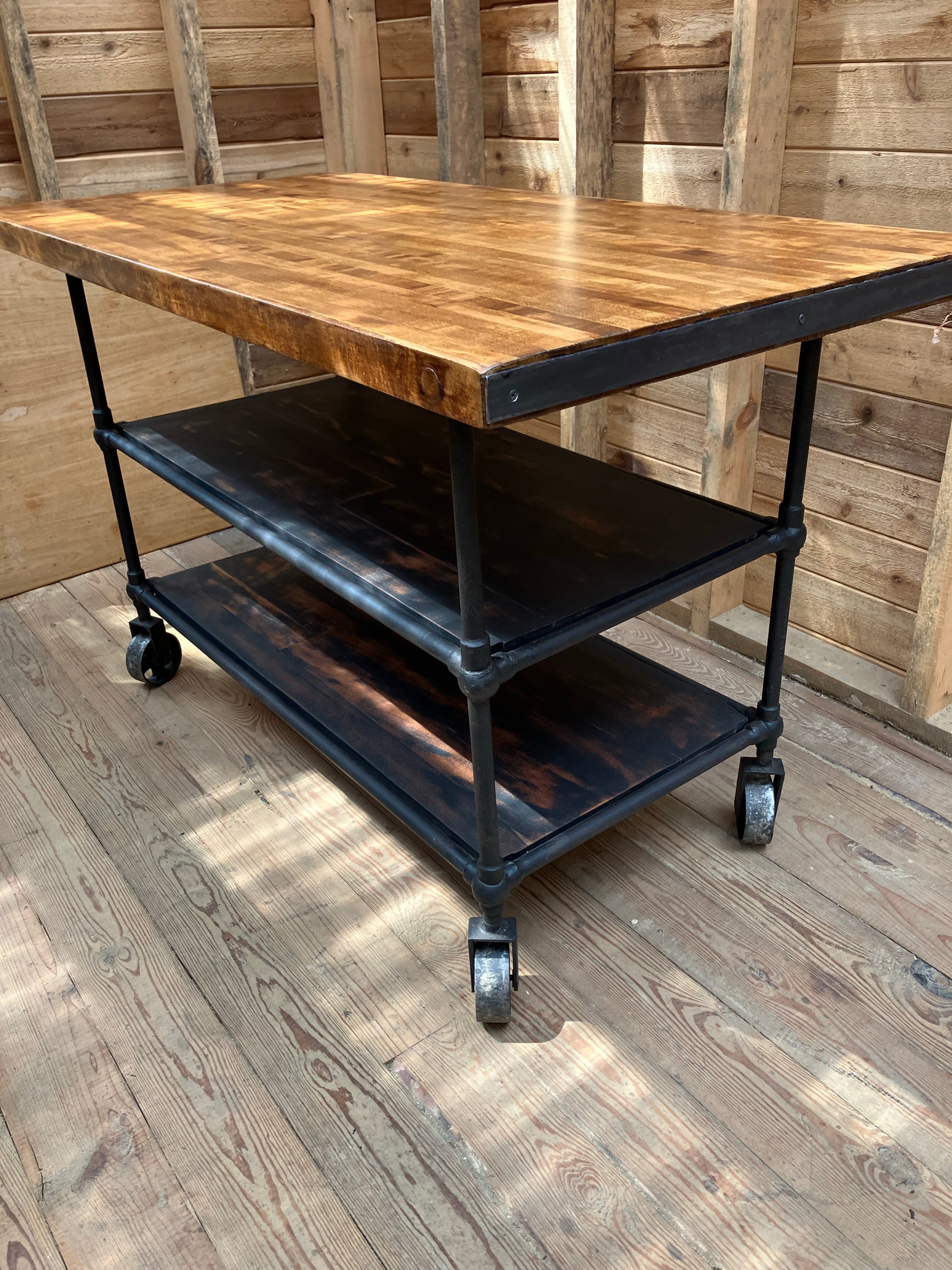 Very nice welded steel base ca 1940’s with vintage restored Maple butcher block top. Heavy steel casters and functional steel edge on each end of the top. Plenty of storage on the two fitted wood shelves below. Great island, work table, or bar cart.