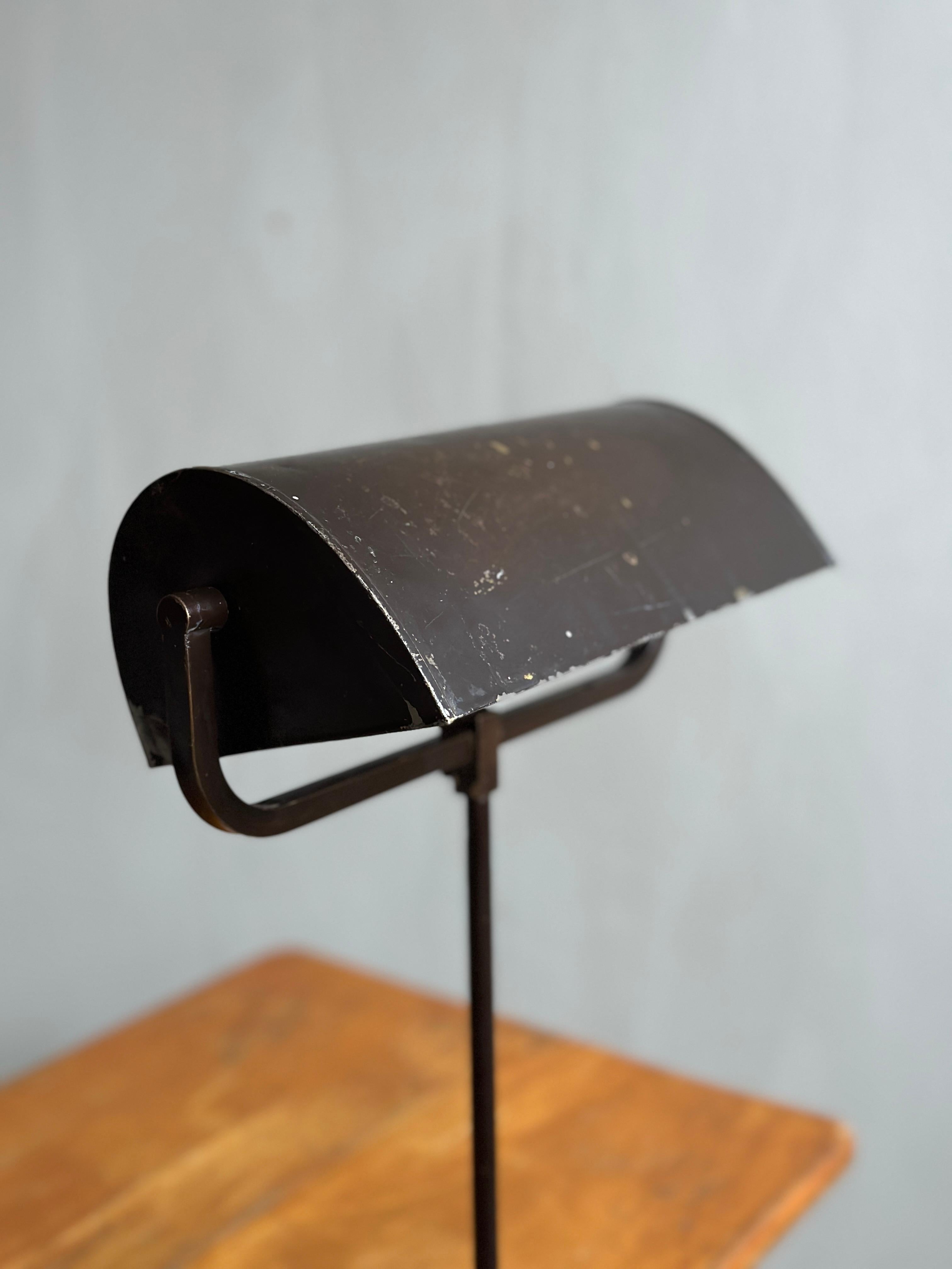 This striking midcentury industrial table lamp is a true vintage gem, hailing from Scandinavia in the 1930s/40s. The lamp is designed to be mounted on various surfaces, such as tables, desks or bedside tables, with a straight arm that extends upward