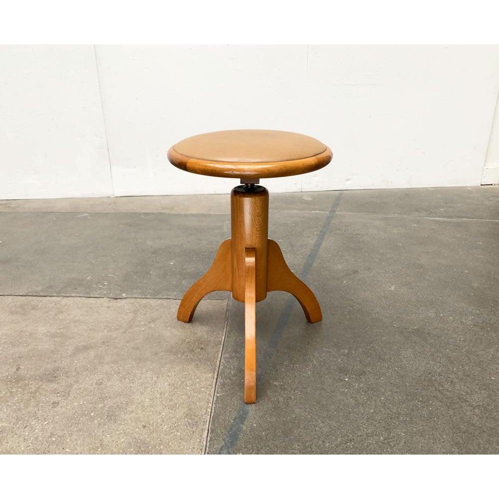 Mid-Century Dreieburzen.

Tabouret simple avec revêtement en cuir synthétique. Les connexions complexes des éléments en bois massif sont frappantes. Les trois jambes partent d'un noyau central et sont faciles à concevoir. Une ornementation subtile