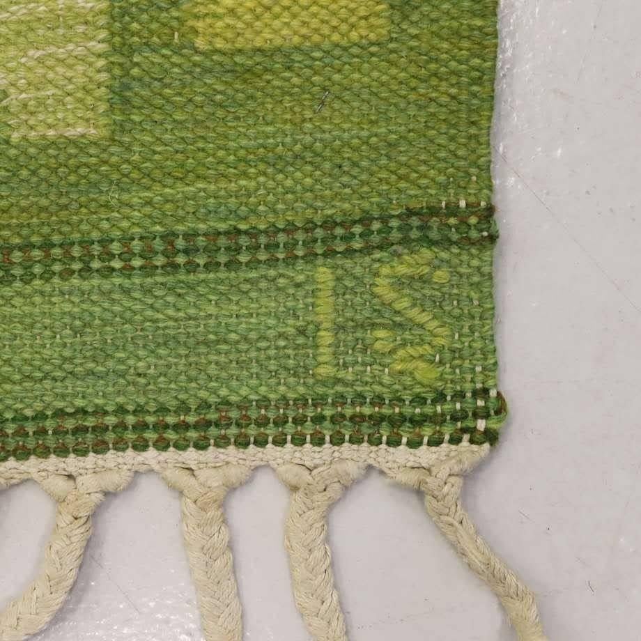Mid century Ingegerd Silow flat-weave Rölakan rug with braided fringe trim on two sides. Geometric design in array of spring greens and cream, good vintage condition, brand marked with IS initials for authenticity.

90.5