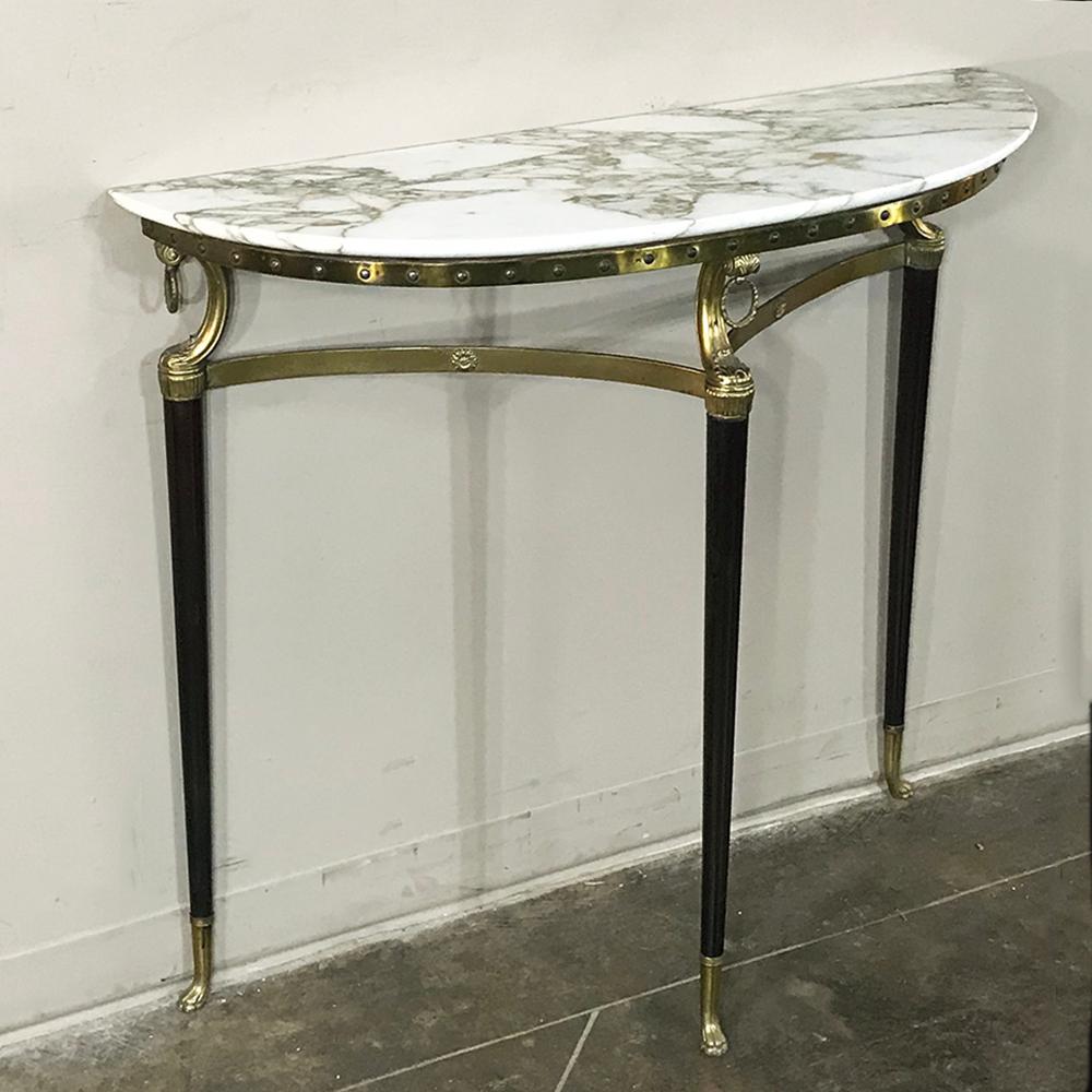 Midcentury inlaid marble and brass demilune console features neoclassical styling with paw feet and finely veined marble for carefree elegance,
circa mid-1900s
Measures: 33 H x 36.5 W x 13 D.
