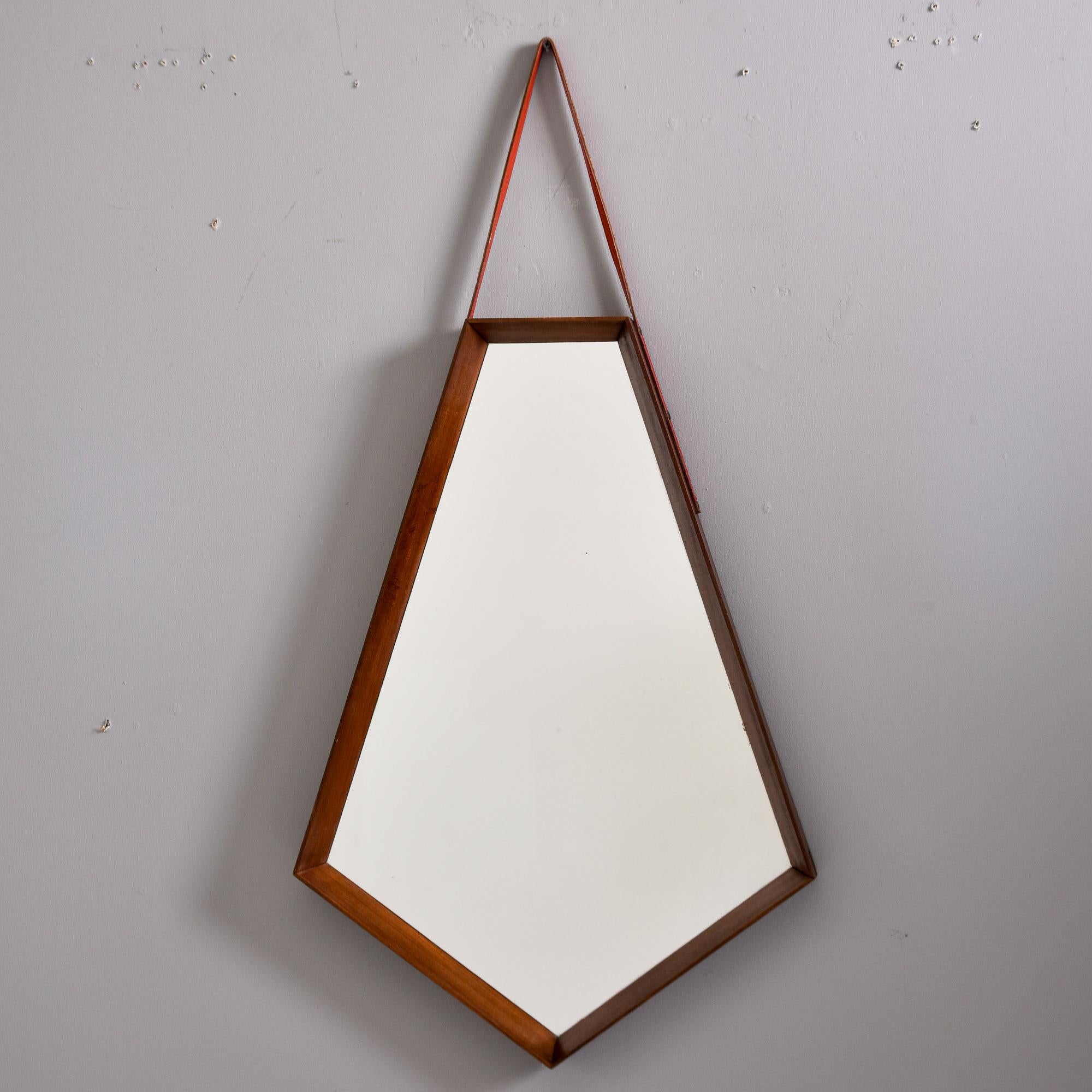 Found in Italy, this mid century mirror has a narrow walnut frame with a five-sided mirror inset and leather hanging strap. Dates from approximately 1960s. Unknown maker. 

Very good overall vintage condition with minor scattered wear to frame and