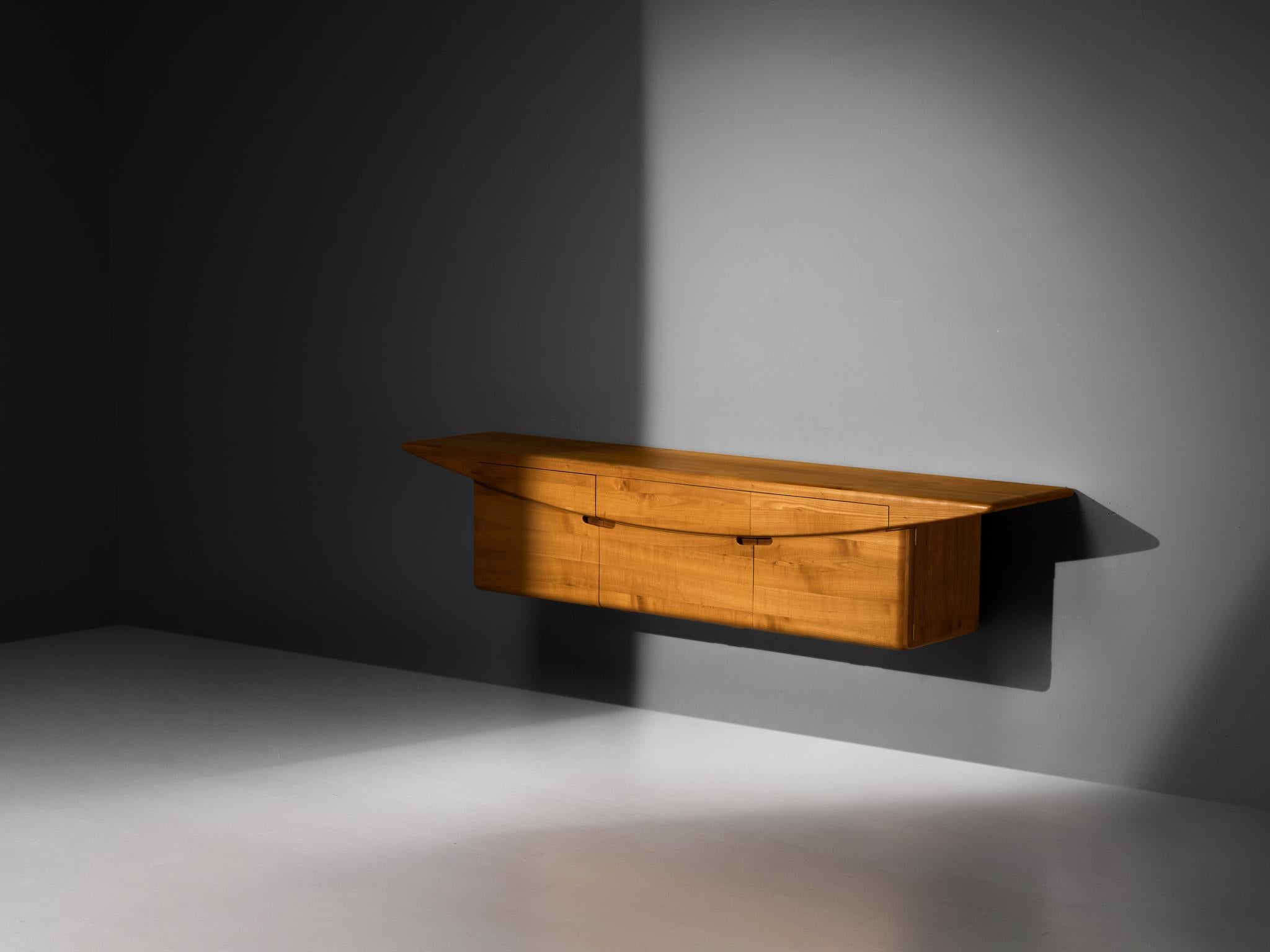 Wall-mounted sideboard, solid elm, brass, Europe, 1992
 
A beautiful European sideboard made from solid elmwood, distinguished by its clean, uninterrupted lines and smooth curves. The craftsmanship clearly reflects the expertise of a skilled