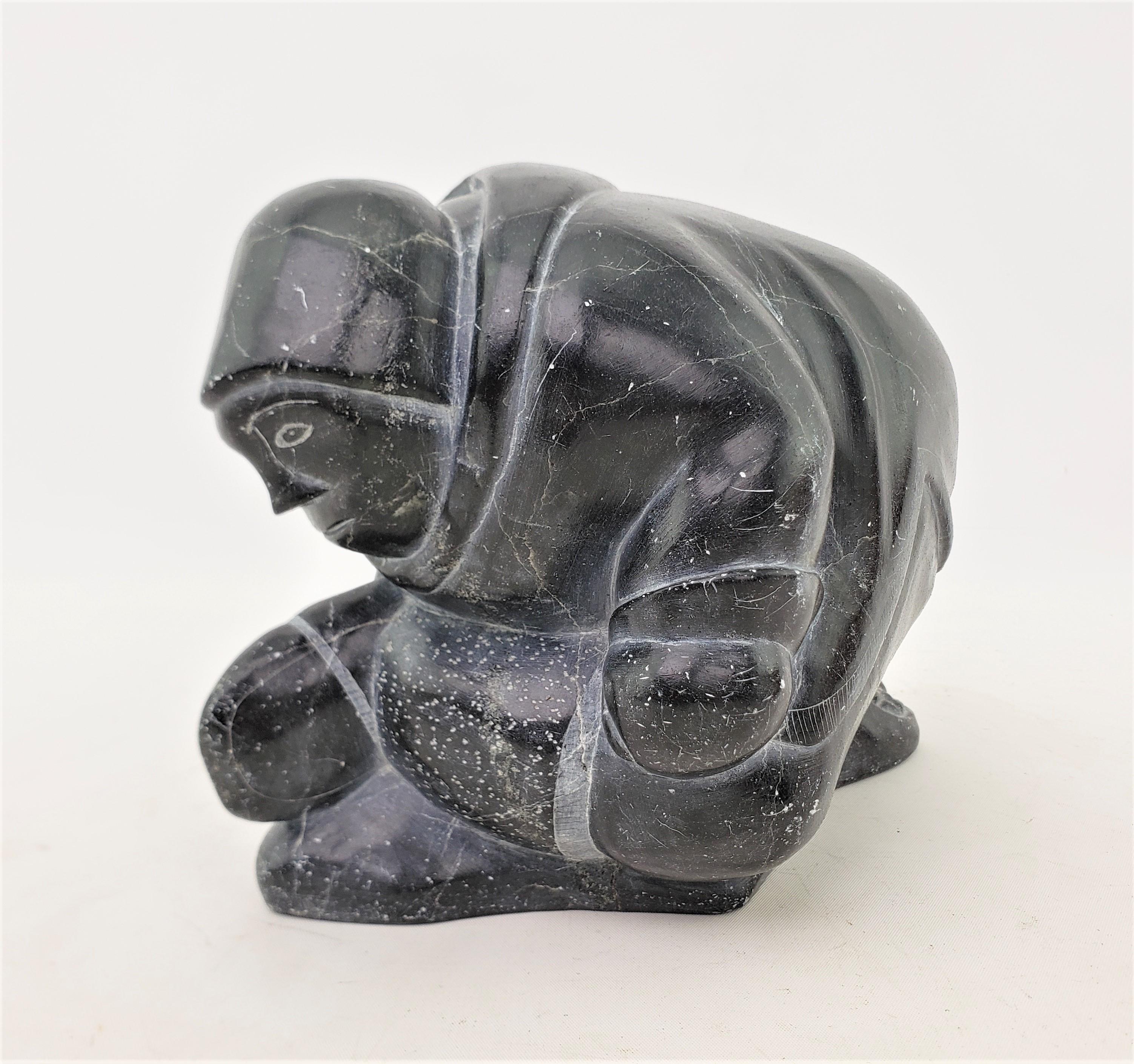 This soapstone figurative sculpture is unsigned, but presumed to have originated from Canada and date to approximately 1965 and done in the Inuit style. This hand-carved soapstone carving depicts an adult Inuit wearing a parka, and kneeling on the
