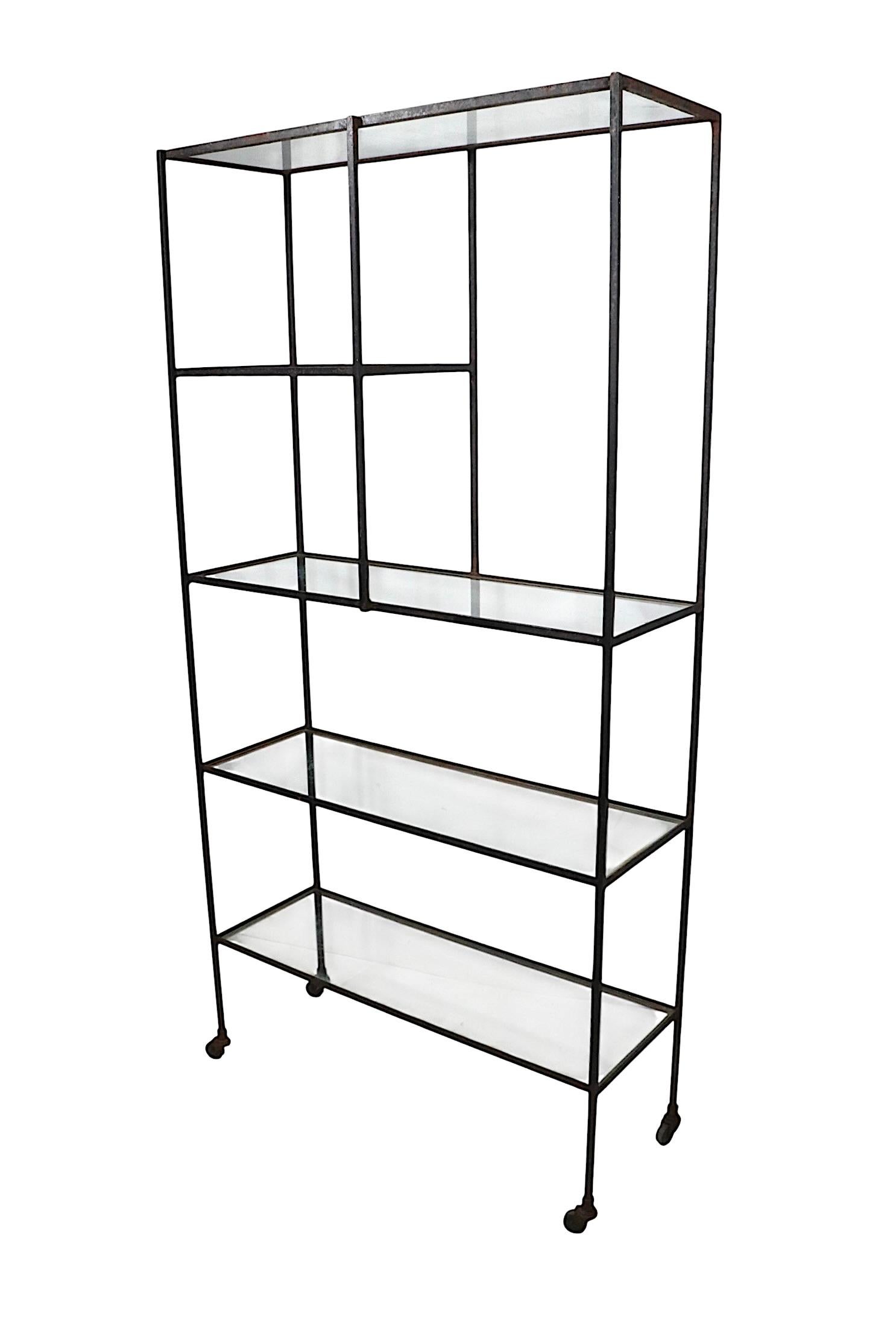 Parete attrezzata, scaffale, costruita in ferro massiccio squadrato con ripiani in vetro. Struttura saldata di buona fattura in ferro, con ripiani in vetro a scomparsa, struttura metallica montata su ruote originali.  Design architettonico MCM che