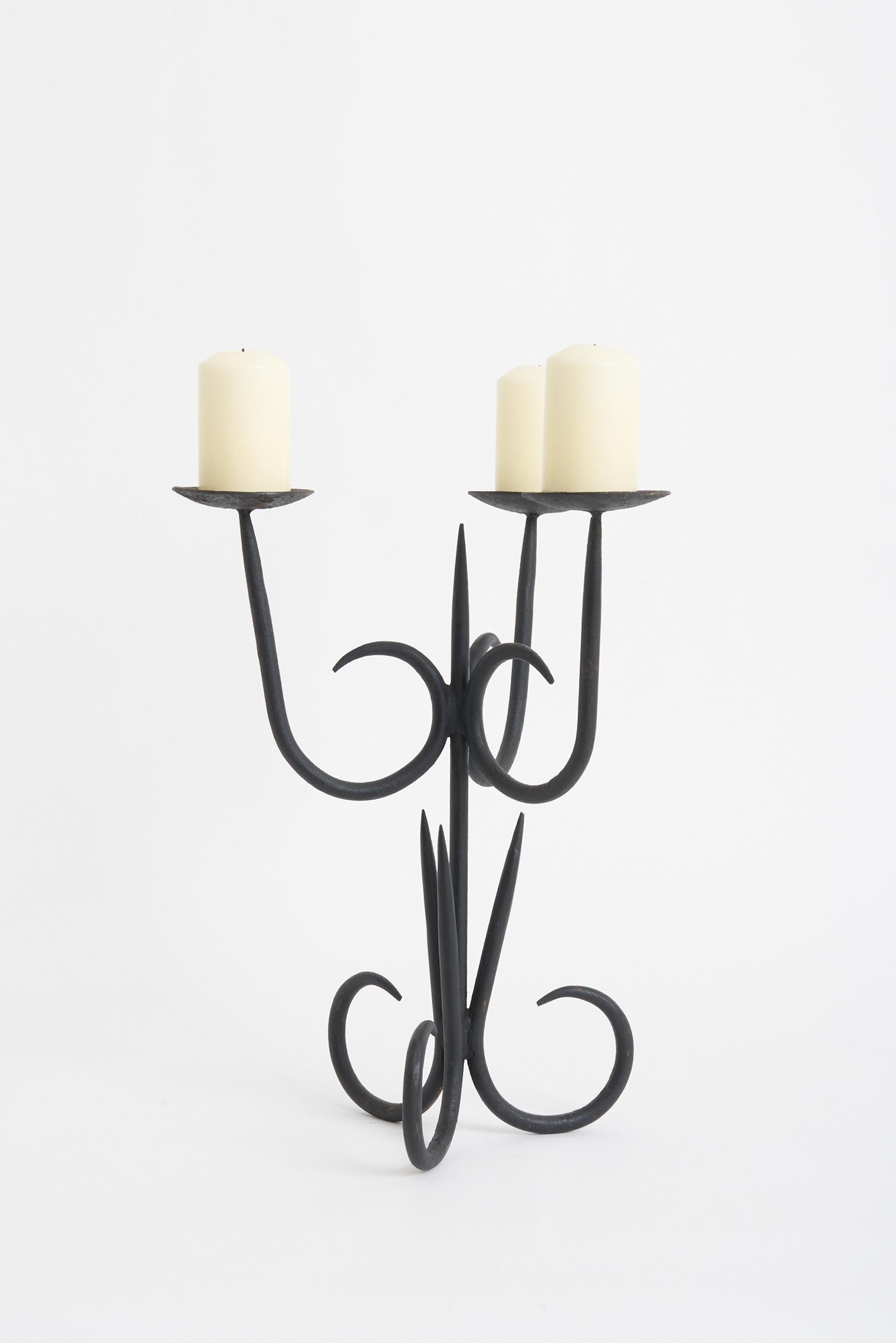 A black wrought iron three-arm candelabra.
France, 1950s.