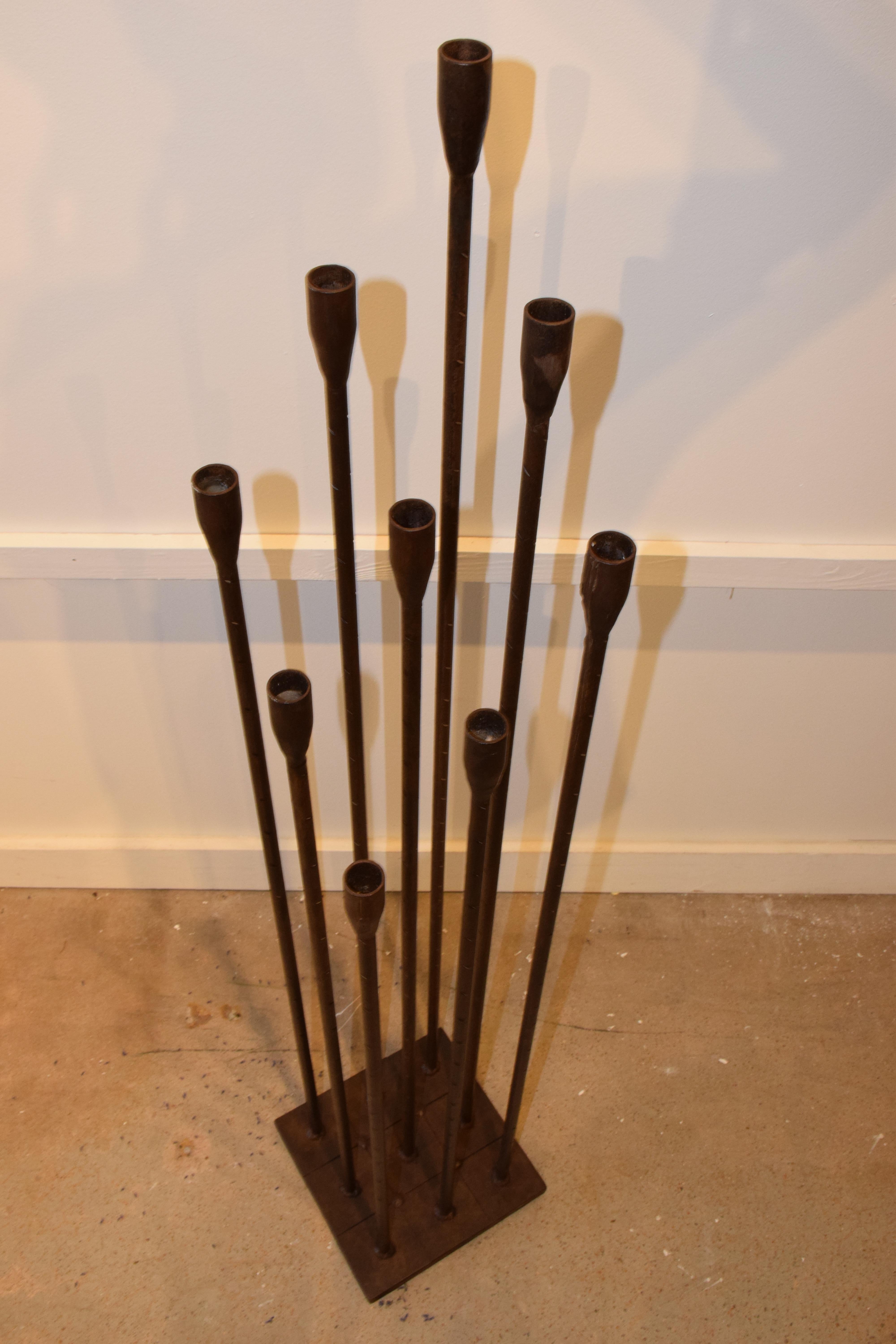 This is a Mid-Century Modern iron candelabra in the style of Harry Bertoia. The 47.5 inch high candelabra features nine rods and candleholders. The iron rods are graduating in size, 31.5