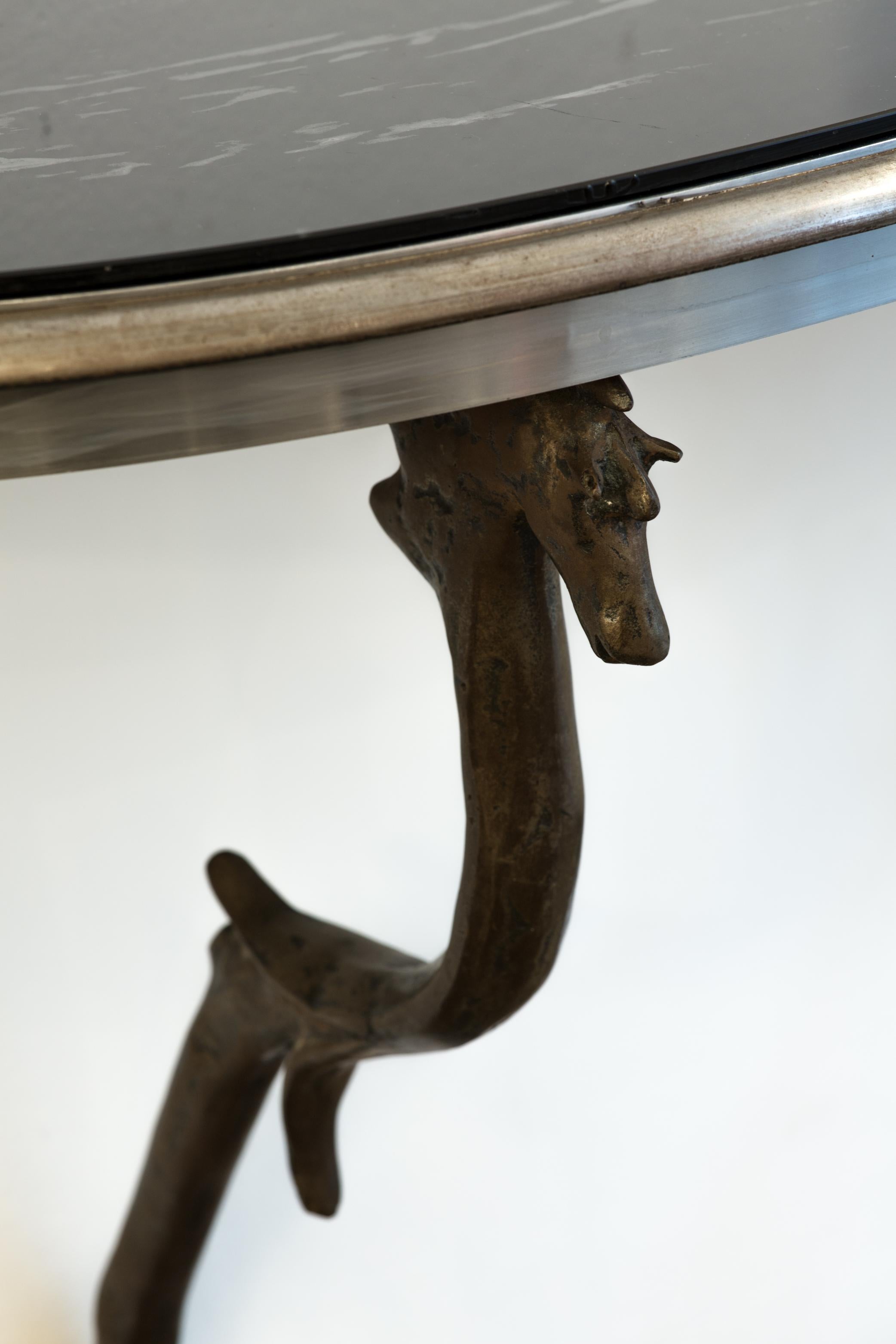 Very unique and untypical midcentury console table from France. The console table has a half round glass top. The glass top is painted black from the background and appears as a marble top, which is rounded by an iron stripe.
The console table