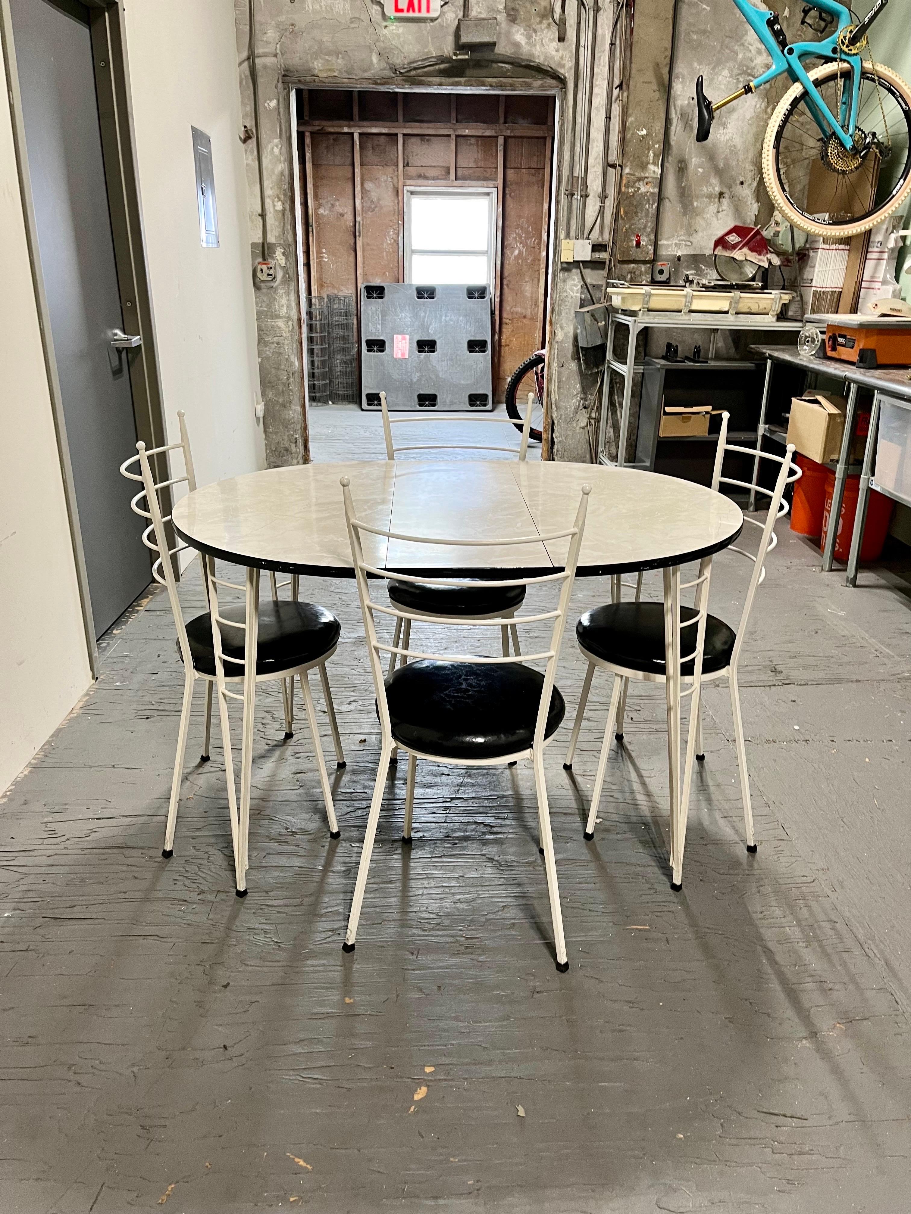 Sleek modern wrought iron and faux marble formica dining table and 4 chairs. Table has 1 leaf. Great period look with a mix of McCobb and Ponti vibes. 
36x30
47.5x30 with leaf.
Curbside to NYC/Philly $400