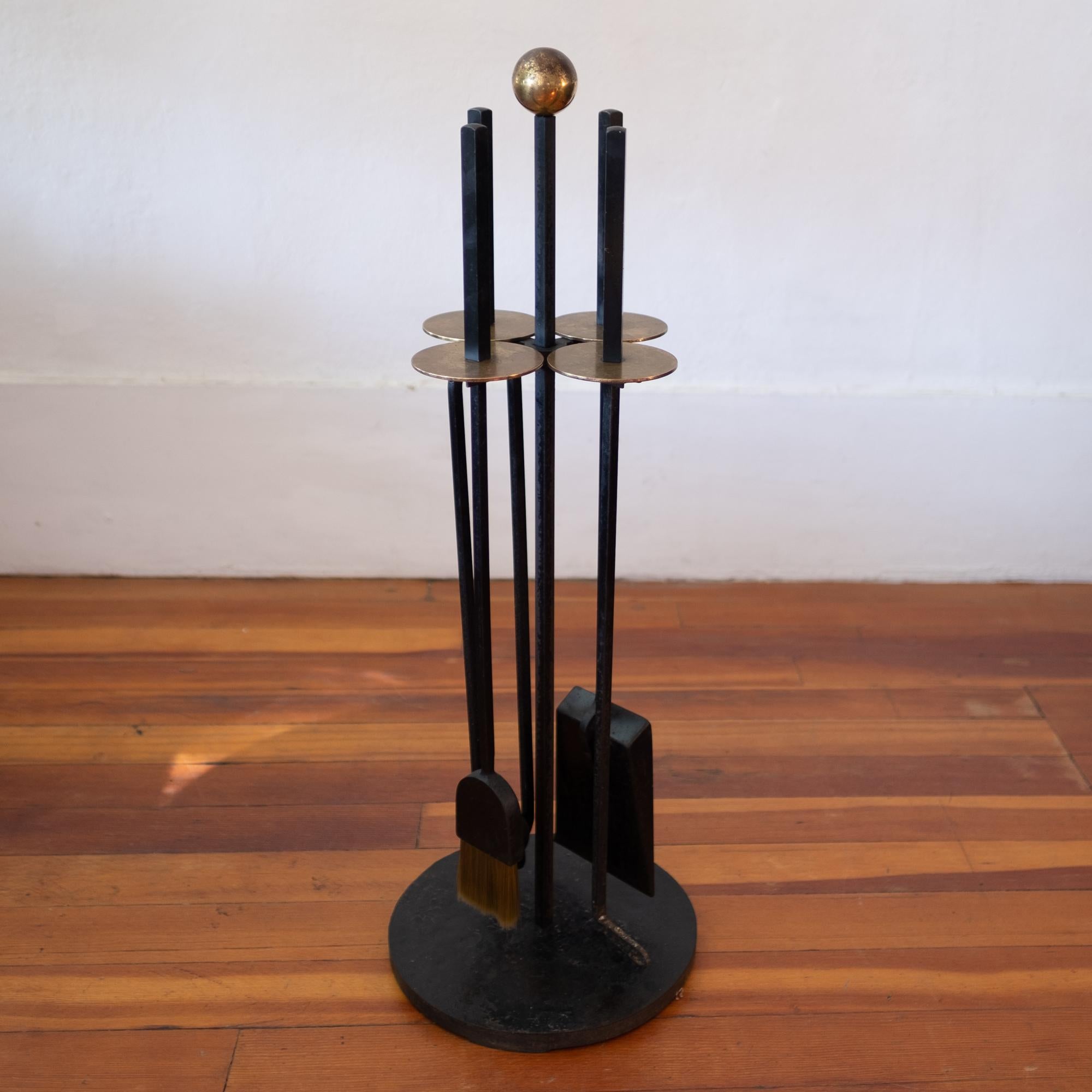 A set of modernist solid iron fireplace tools with solid brass discs and ball. The set includes a shovel, broom, poker and log grabber. High quality and substantial construction with the original finish. 1950s

The set was designed by California