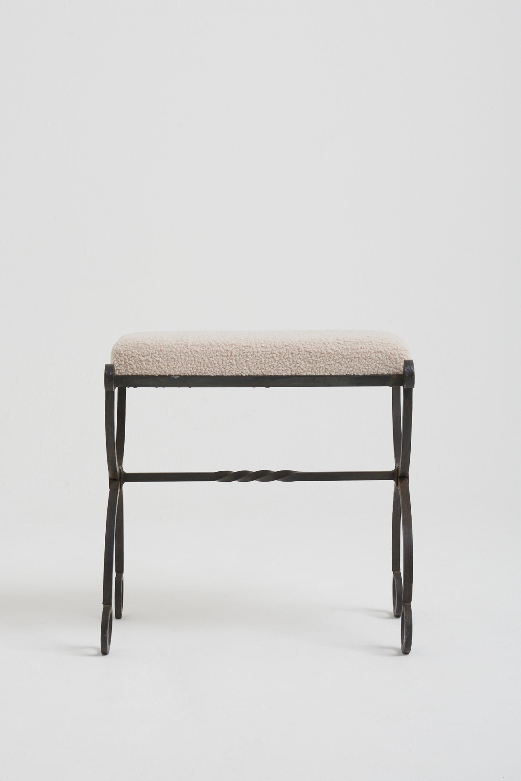 A wrought iron stool, upholstered in boucle.
France, circa 1950.