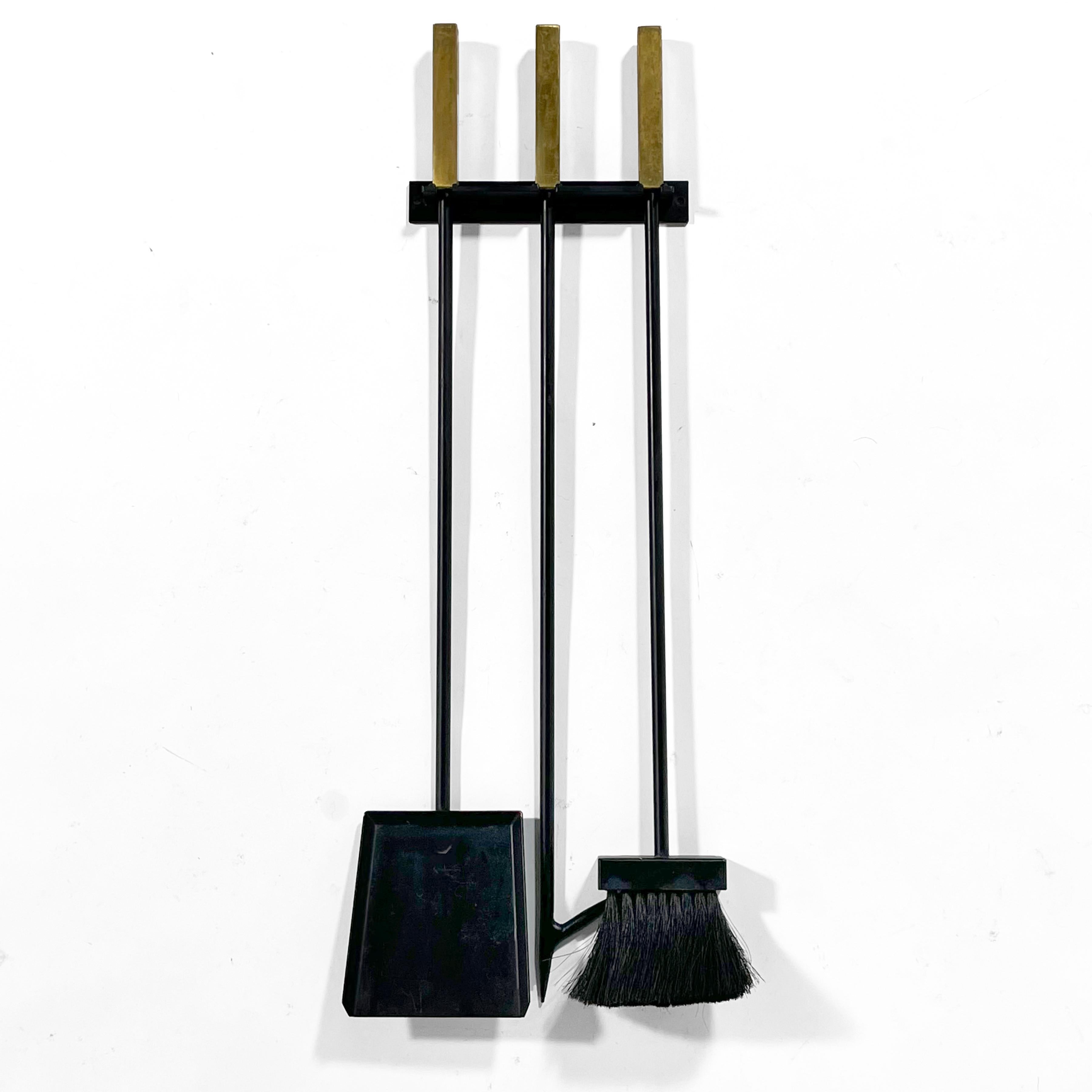 These handsome and very well made vintage mid-century fire tools have square stock brass handles and hang on the wall via a wall-mounted bracket.

29.25