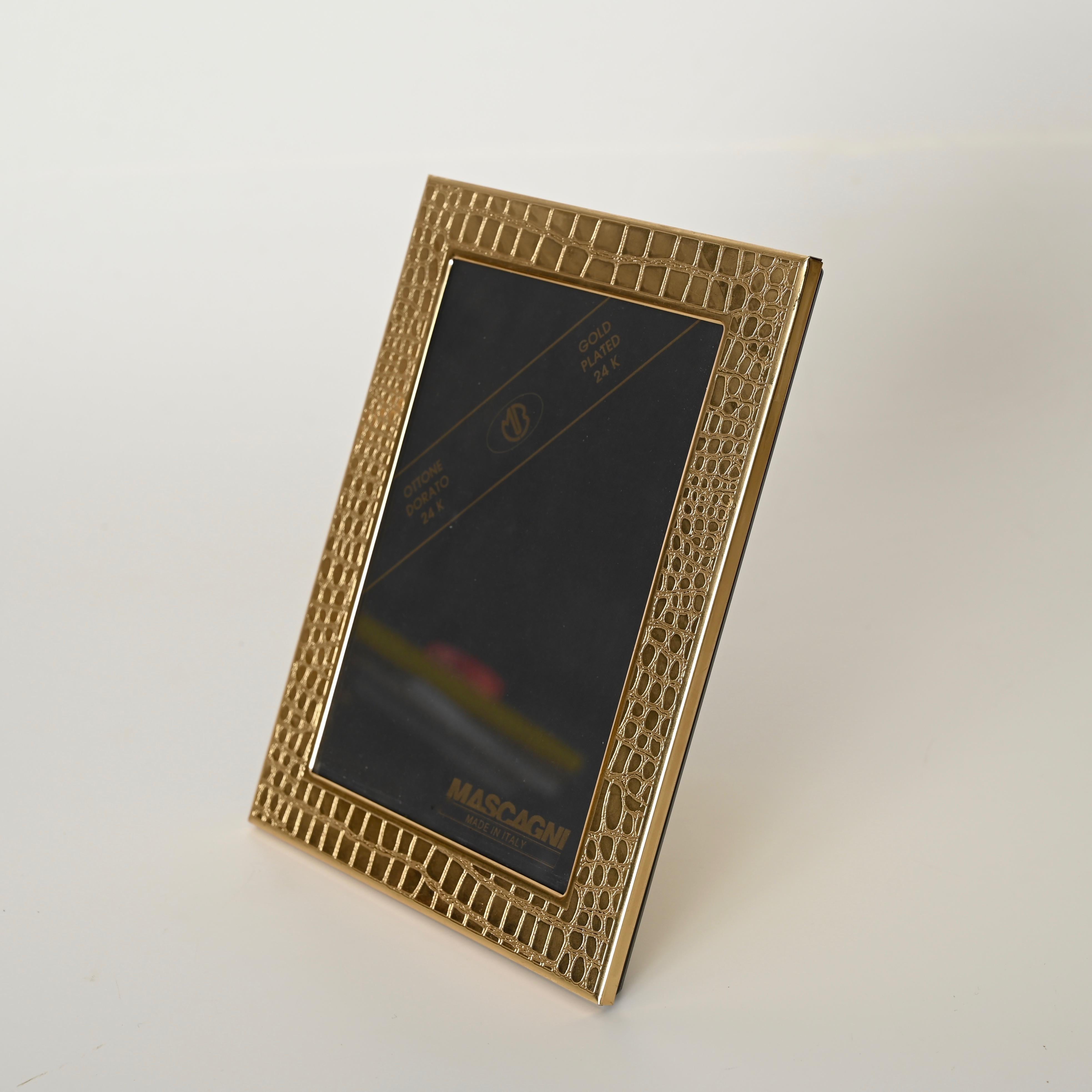 Maravilloso e increíblemente raro marco de fotos de latón chapado en oro de 24 quilates con efecto de piel sintética de cocodrilo. Diseñada por Umberto Mascagni y producida en Italia durante la década de 1970.

Este elegante marco de fotos está en