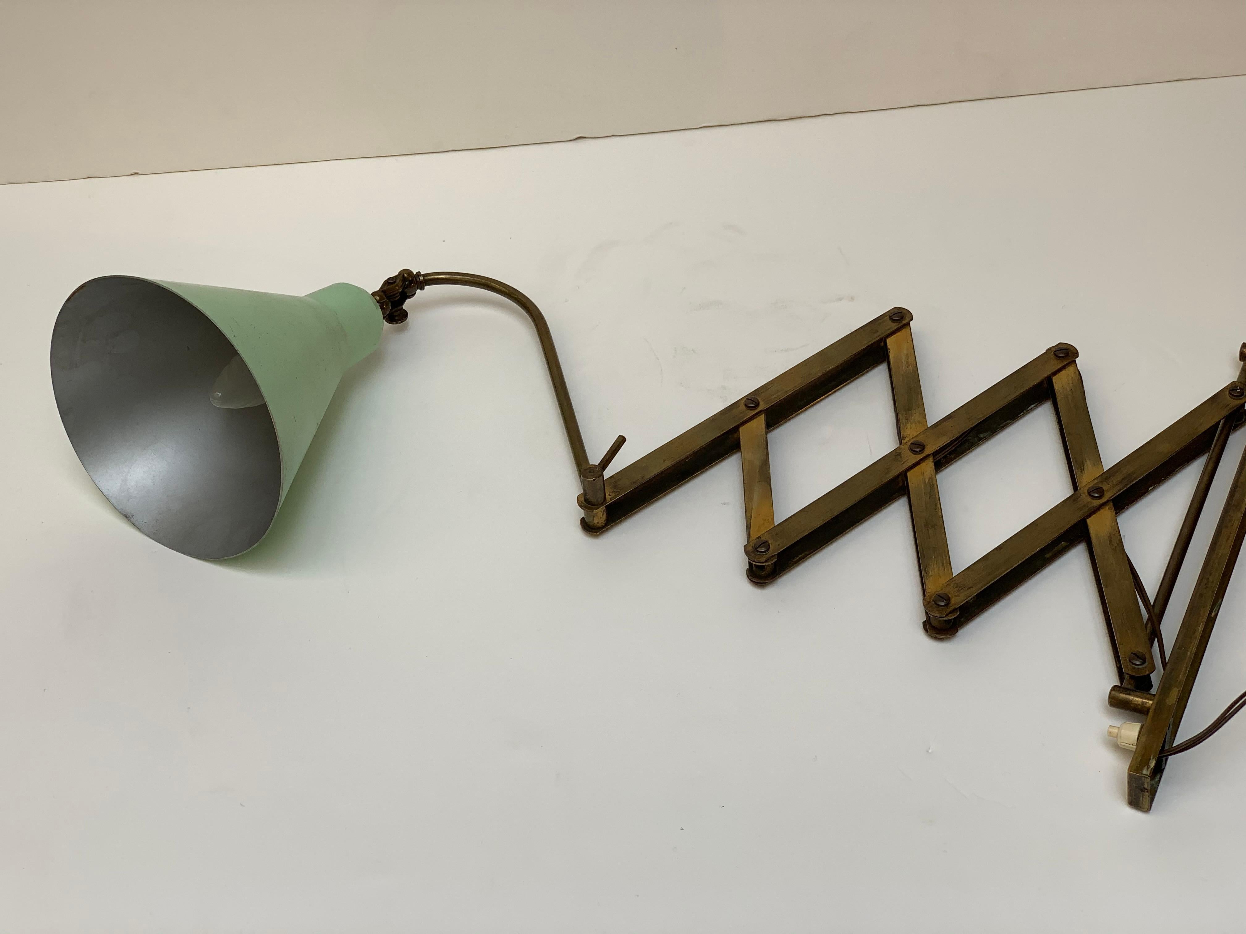 Midcentury 1950s Italian wall lamp with extendable arm, through a scissor mechanism it can be extended and shortened towards the wall, turned left and right thanks to a joint positioned in the structure attached to the wall, the lacquered aluminum