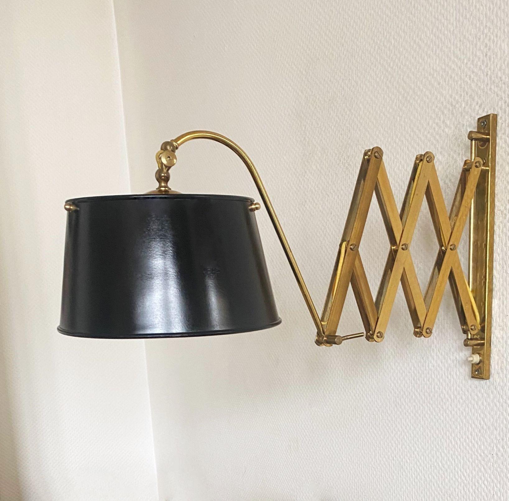 A high-quality brass wall lamp with adjustable scissor arm, Italy, 1940s. Italian Mid-Century design with precise craftsmanship made of gild polished brass, shade of lacquered metal - outside black and inside gilded. The swivel arm system enables
