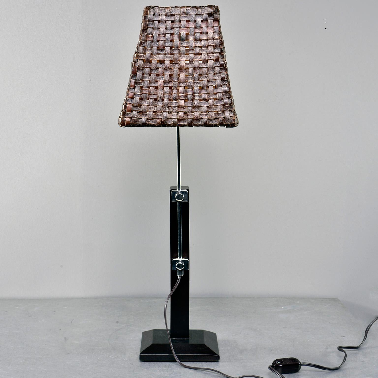 Italian table lamp has a sleek dark wood base with polished nickel adjustable support. Height can be adjusted from 31”-25”. Single candelabra sized socket. Original hand woven leather shade. Electrical has been updated for US standards. Rocker