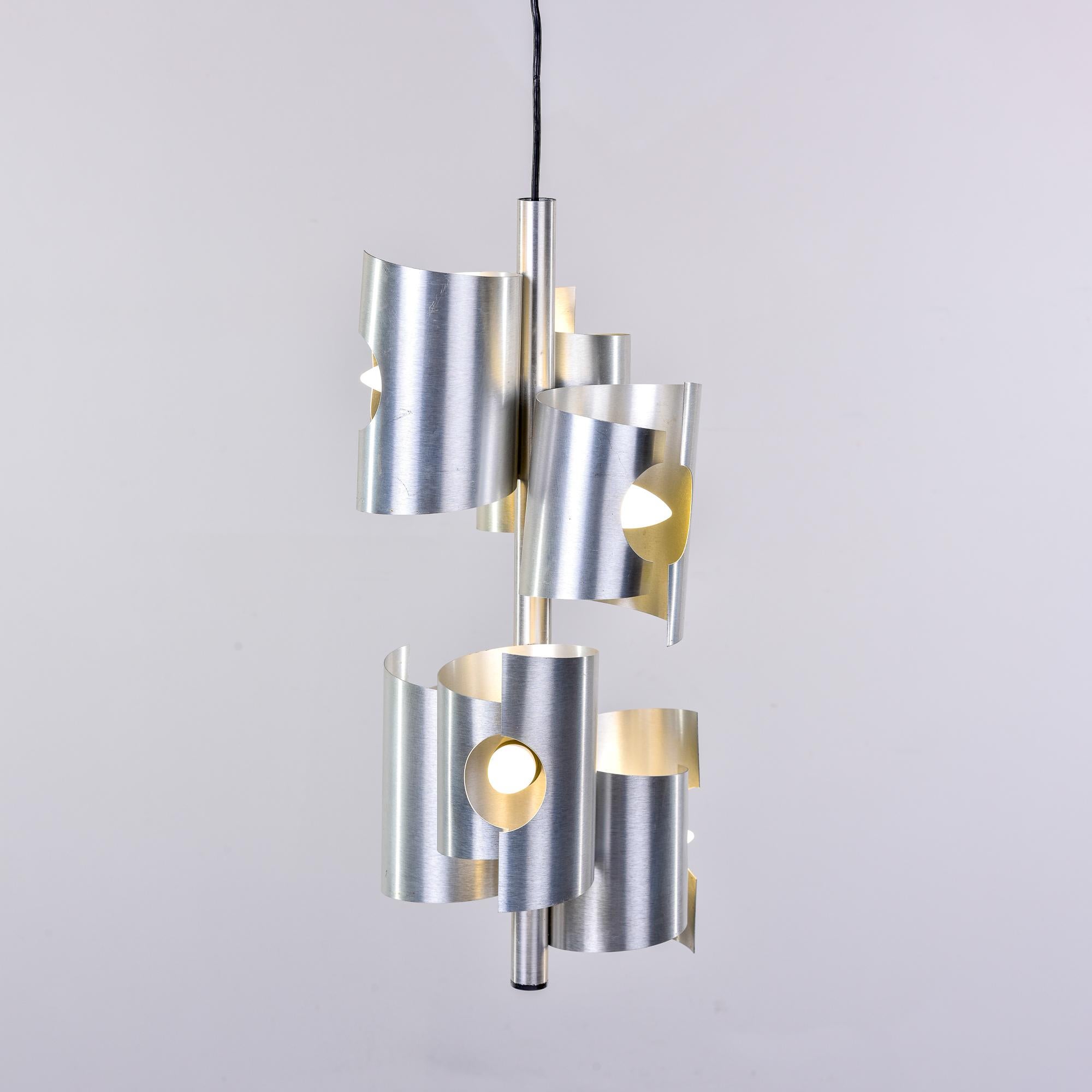 Found in Italy, this circa 1960s hanging pendant has two tiers of three staggered aluminum tubes with cut outs for the bulbs. Six lights in total with standard sized sockets. Fixture has been rewired for US electrical standards. Smaller pendant in
