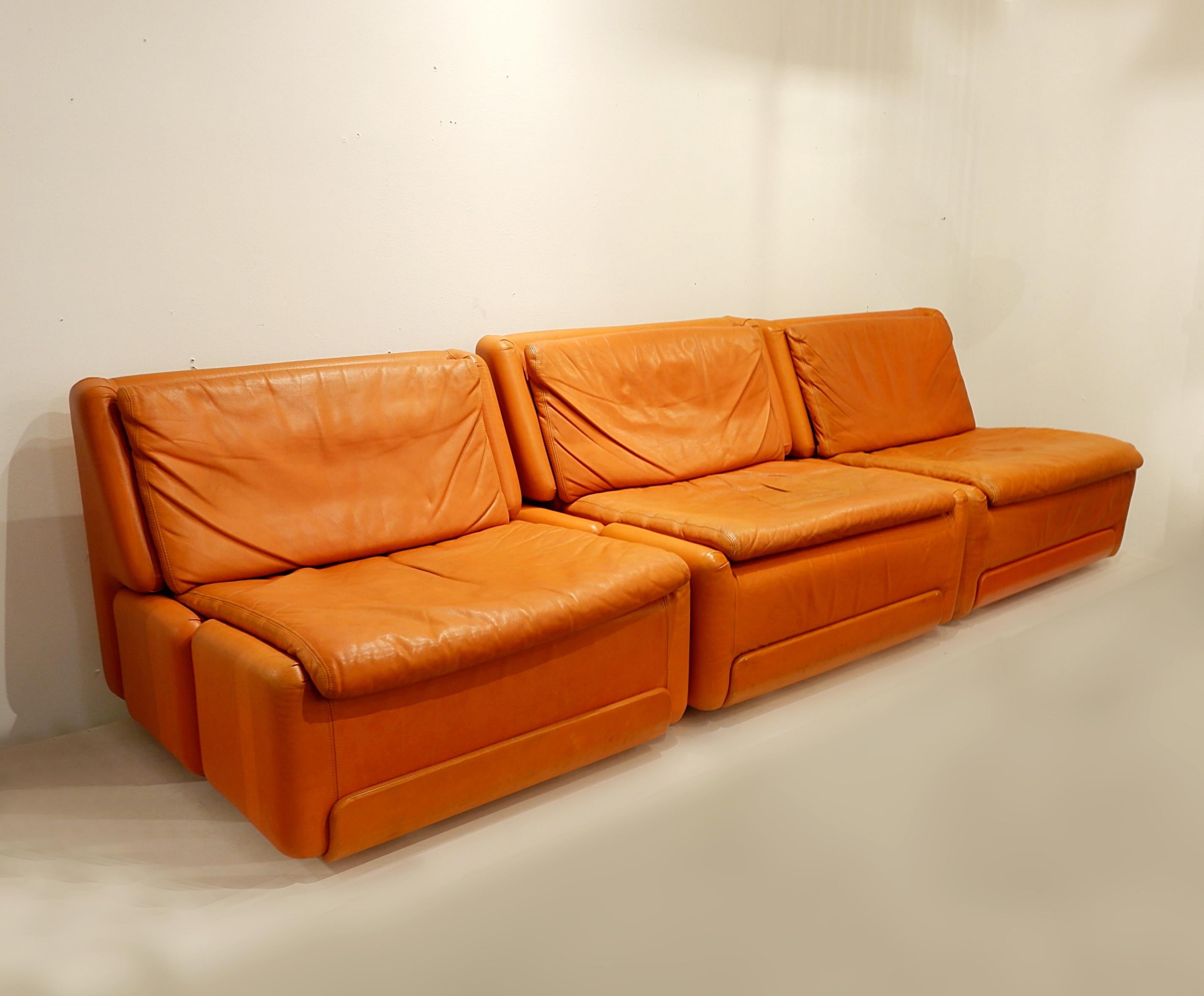 Comfortable and well designed armchairs in orange leather. These armchairs have a pleasant patina and an easy shape for most interior. They can bring a touch of colour or complement an already colourful area. There are five available.