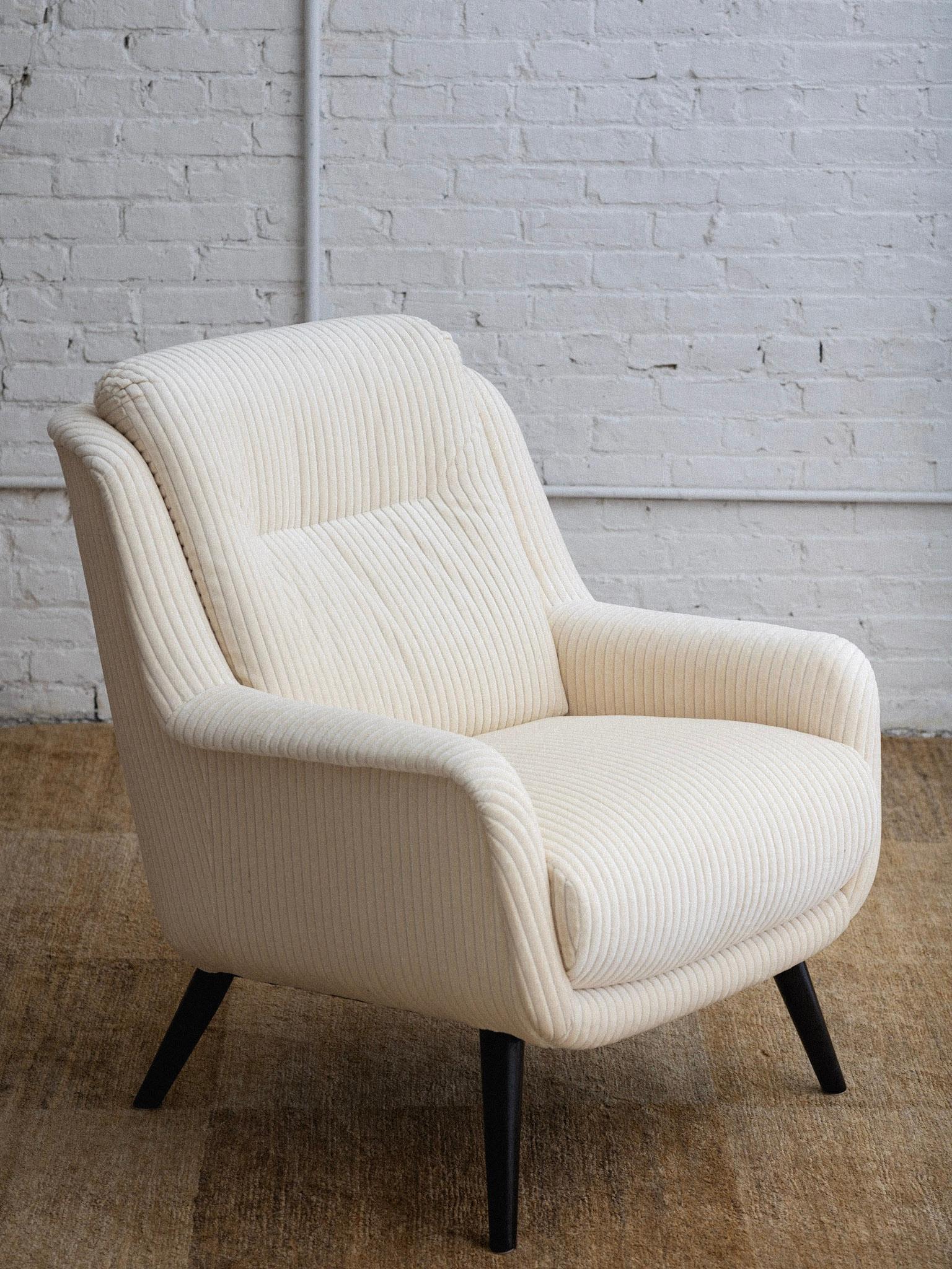 A mid century Italian armchair. Newly reupholstered in a cream velvet corduroy. Black painted wood legs. Pair available, sold individually. Sourced in Northern Italy. 