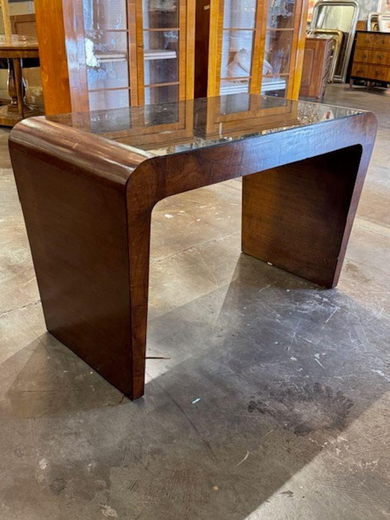 Dieser hübsche italienische Schreibtisch aus Nussbaumholz versprüht mit seinem Art-déco-Stil den Charme der Jahrhundertmitte. Die Glasplatte verleiht dem Tisch einen funktionalen Hauch von Eleganz, während das stilvolle Stück jedem Raum einen Hauch