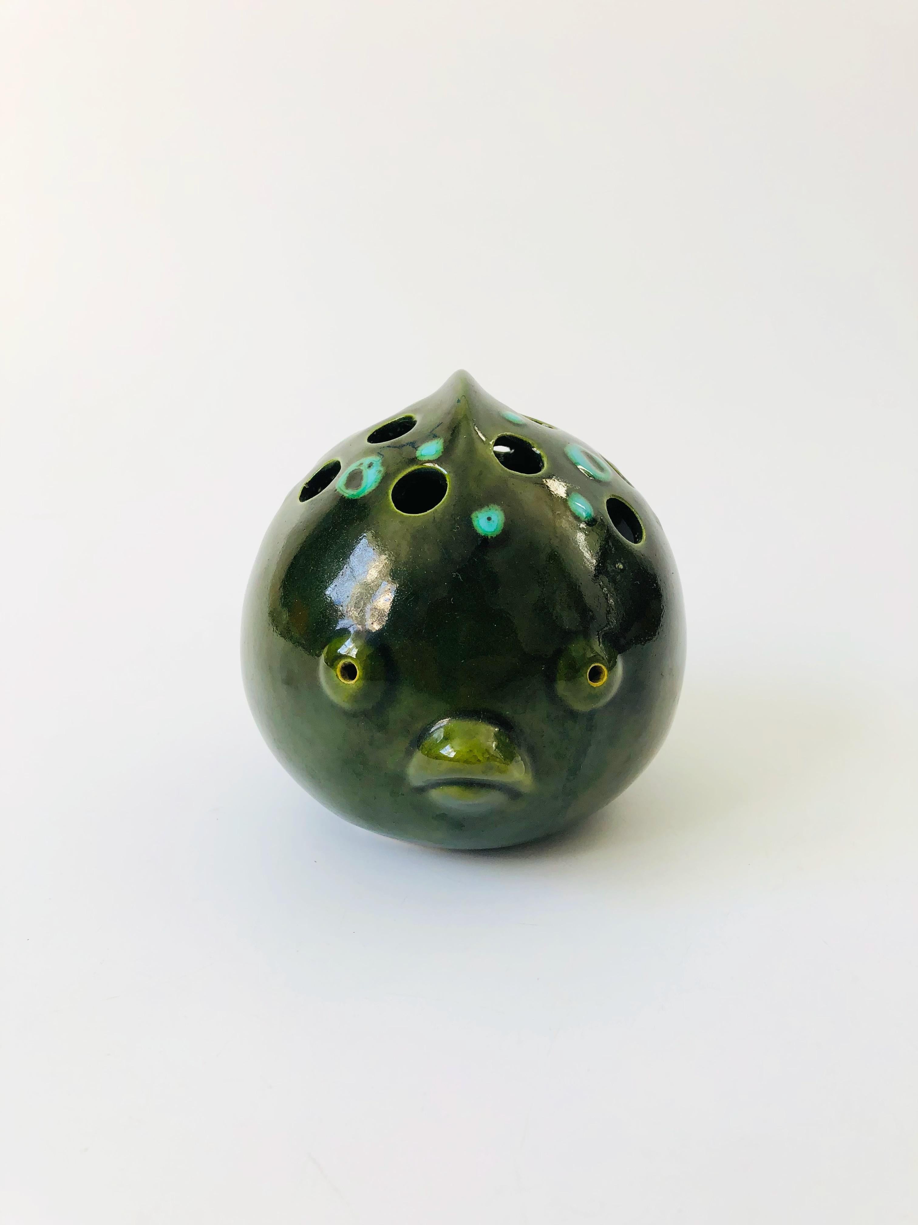 A mid century Bitossi style Italian art pottery vase in the shape of puffer fish. Several holes on the top can be used for floral arrangements. Great stylized detailing and form to the fish with beautiful green and blue glazes. Marked on the bottom
