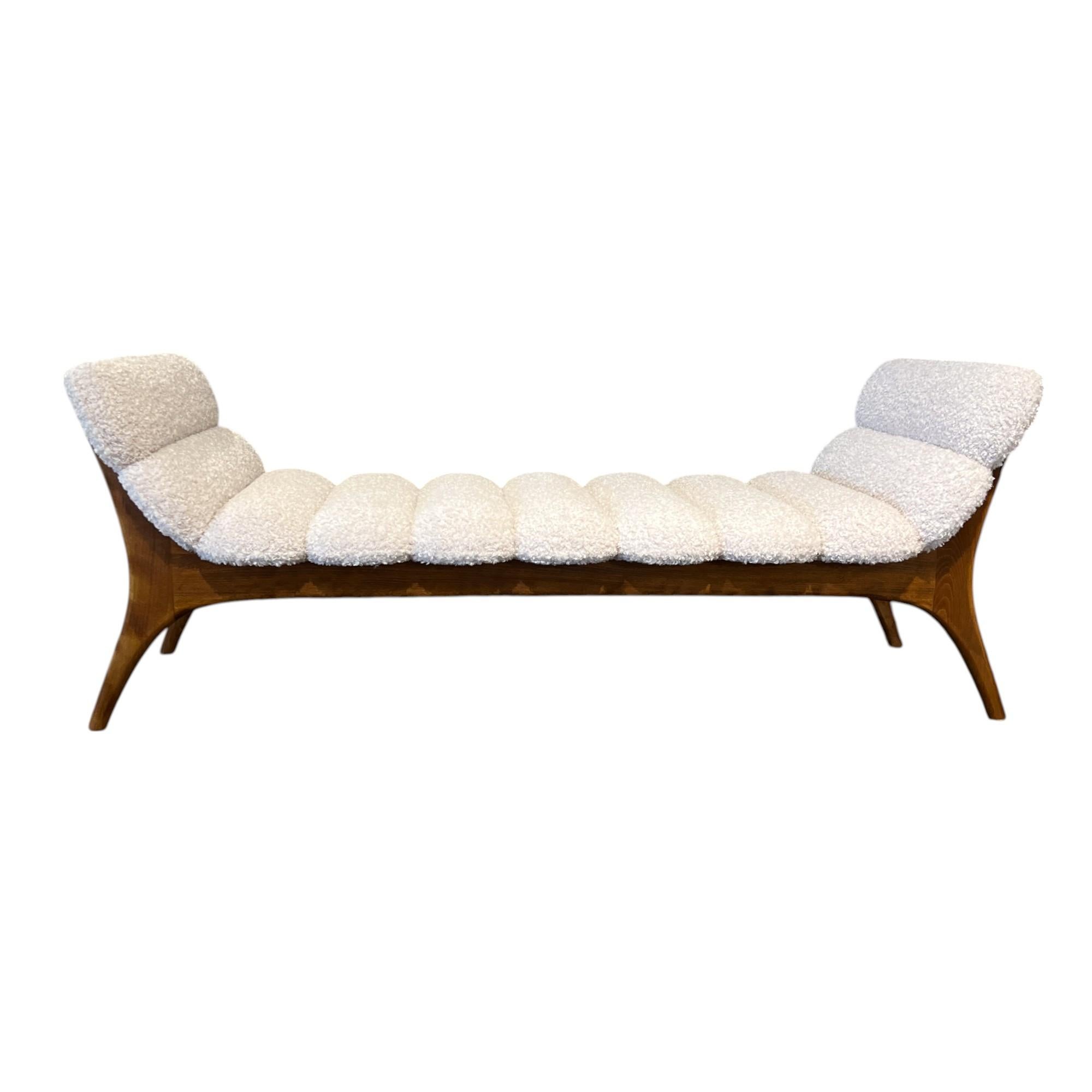 A sleek mid-century Italian ash bench featuring clean, architectural lines and upholstered in plush bouclé—balancing warm wood tones with soft texture for a sophisticated modern statement.