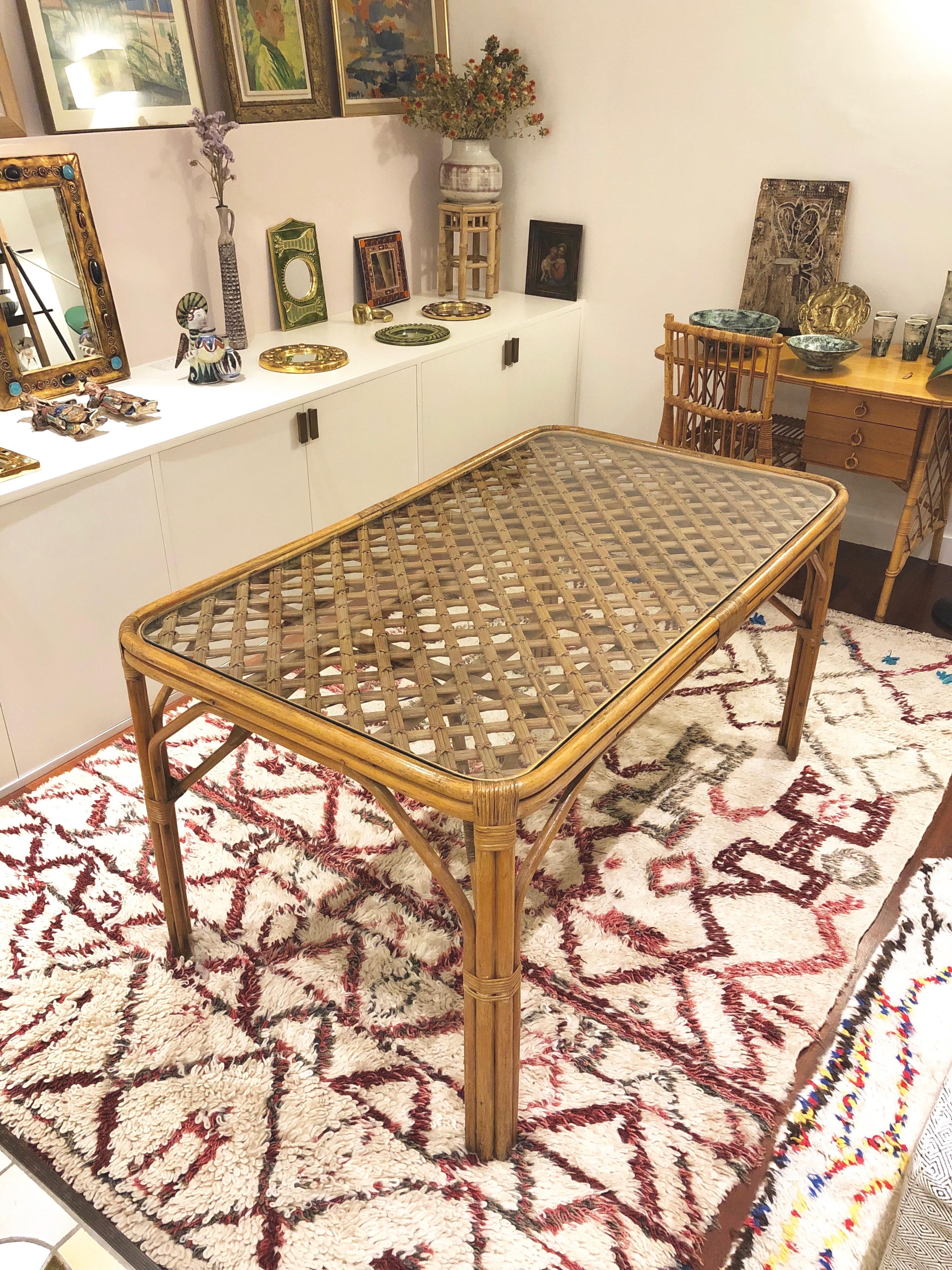 Midcentury Italian bamboo and rattan table, circa 1960s. An absolutely stunning table which mixes flair, character and practicality. The table is a mix of bamboo and rattan covered on the cross-hatched surface by a protective, fitted glass piece.