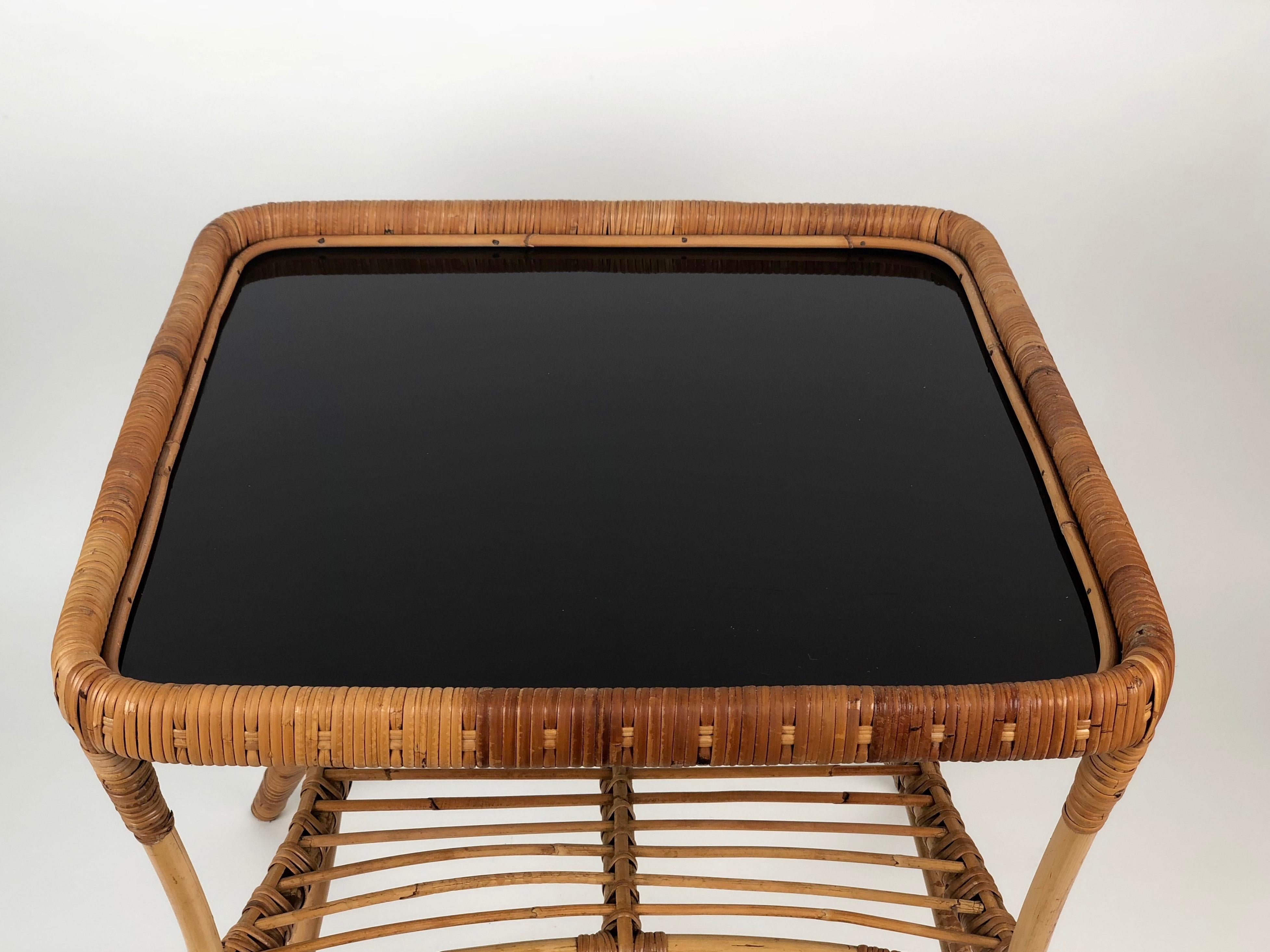 Deux chaises et une charmante table basse en bambou et osier. La table a un plateau en verre opalin noir.
Design italien. Toutes les pièces sont en bon état.