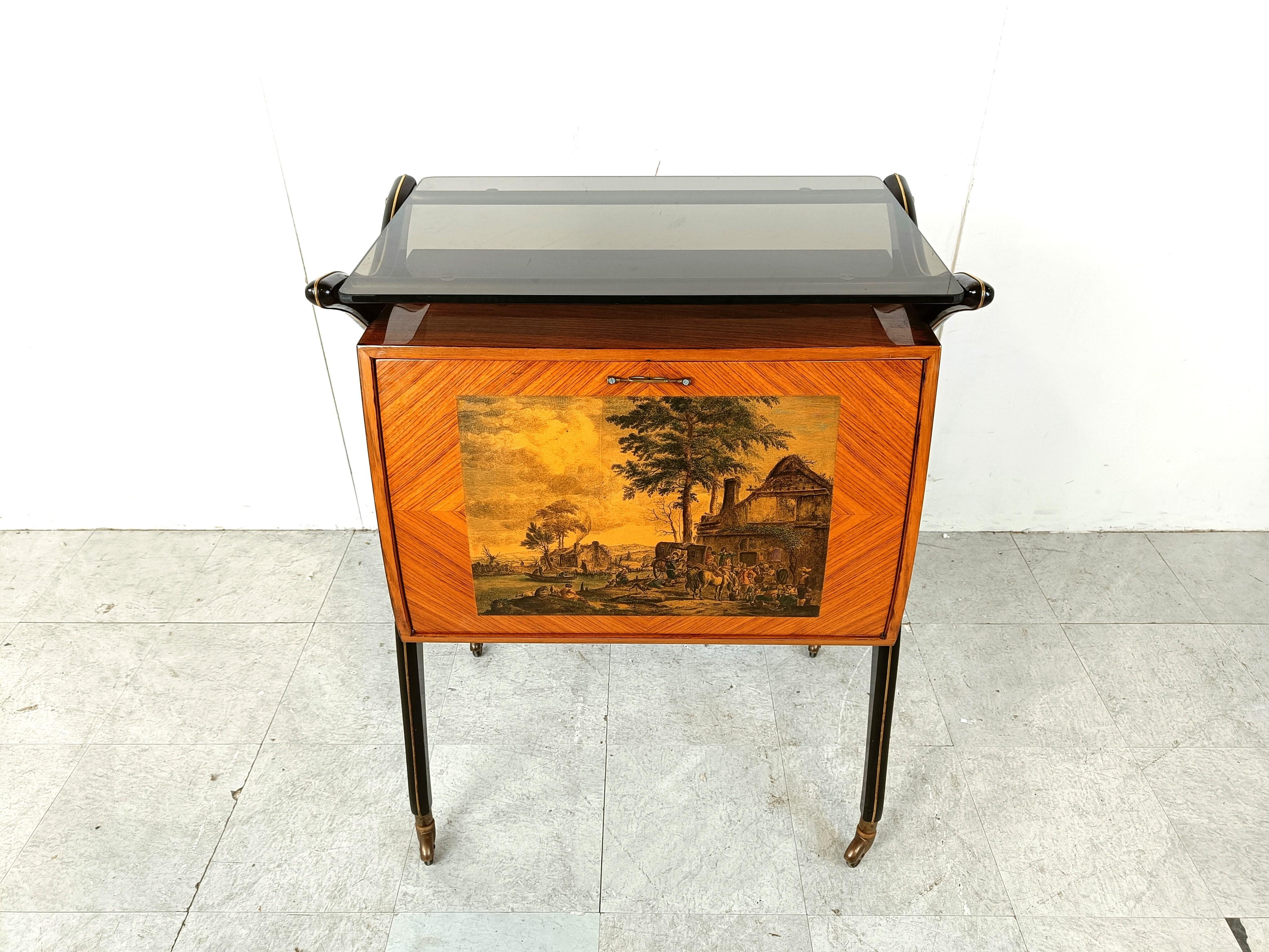 Mid century dry bar attributed to italian designer Cesare Lacca.

This unusual bar has a landscape litho on the front.

The inside of this cabinet is covered with a mosaic of mirrored glass and 2 small glass shelves with brass details. It has a