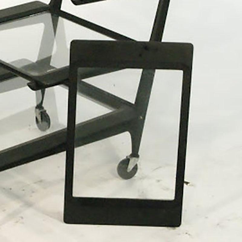 This Italian Mid-Century Modern ebonized bar or tea cart by Cesare Lacca was most recently featured in Mad Men. The sculptural bar cart or tea caddy features three removable shelves and a rare ice and bottle holder. 

Stamped made in Italy.