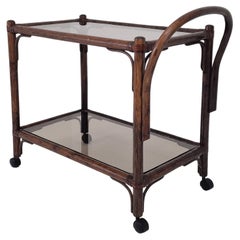Carrello o trolley in legno di bengala e vetro fumé, anni '70