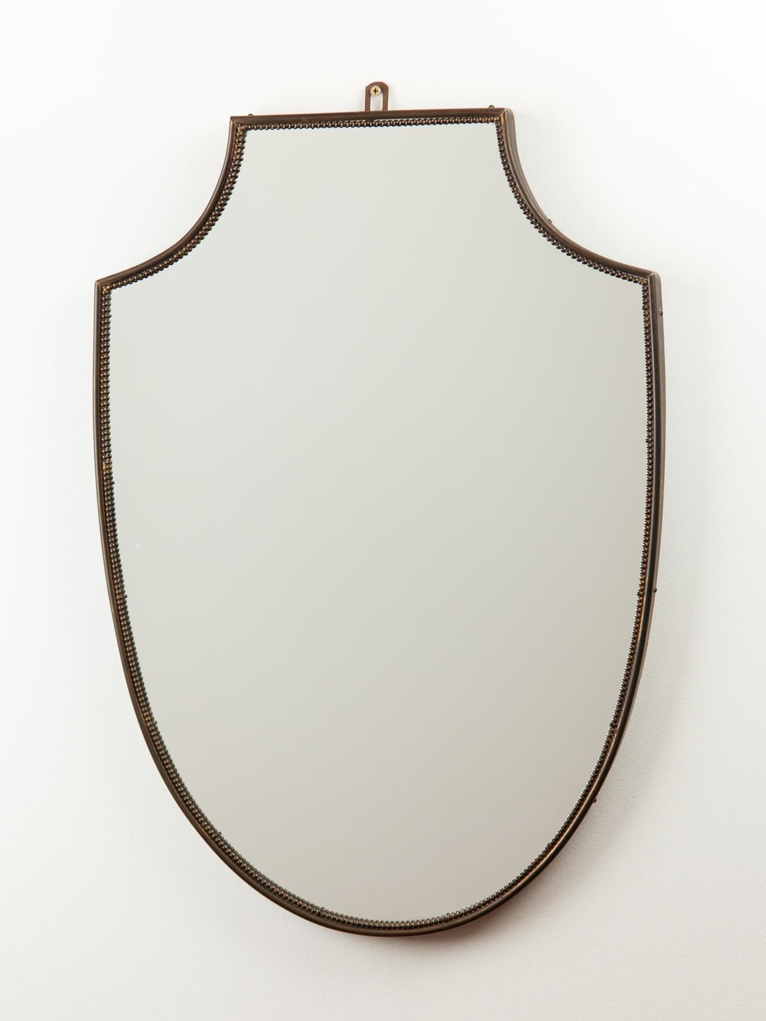Italienischer Vintage-Spiegel aus Messing mit einer Einfassung aus Messingperlen. Die klassische Form verkörpert das Design der italienischen Moderne. Der Messingrahmen hält das Glas und die Holzunterlage mit einem Haken am oberen Rahmen.
