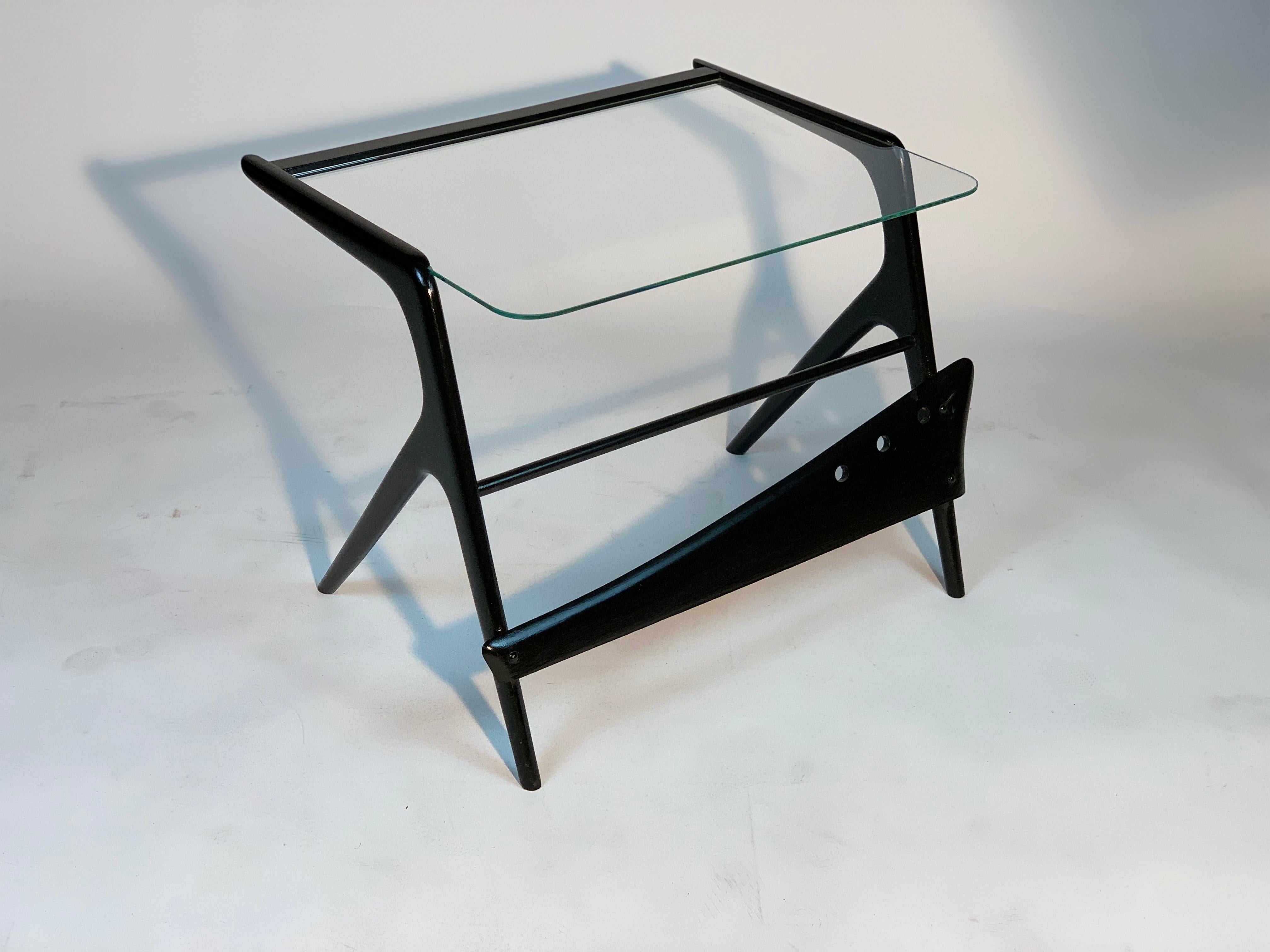 Mid Century Italian coffee table with an architectural structure composed of fluid and snappy lines and elements in black lacquered wood with an aerodynamic and slender shape that recall the shape of boomerangs.
The use of this coffee table, also