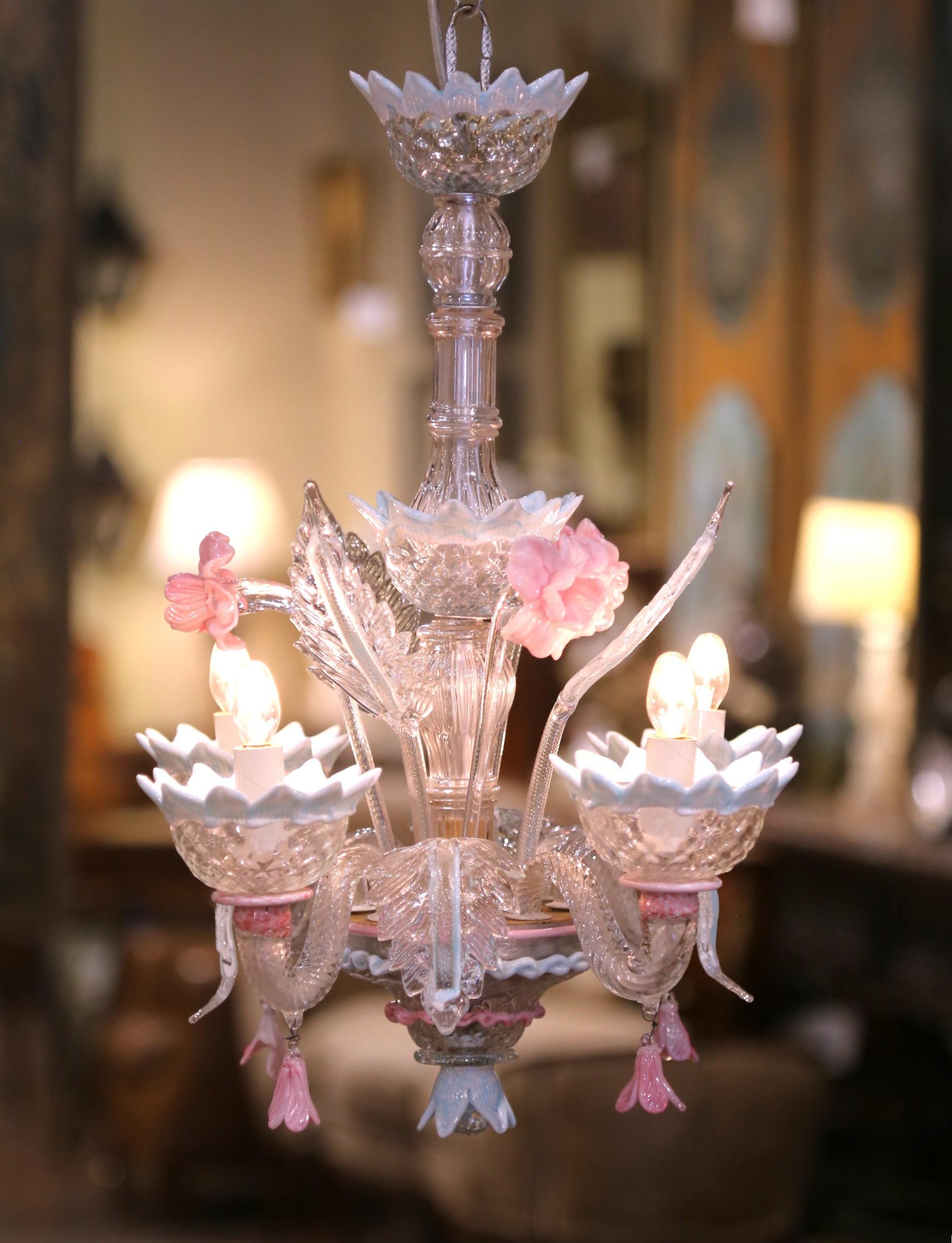 
Add a delicate touch of Venetian charm to your interior with this petite Murano glass chandelier. Hand-blown in Italy circa 1960, the elegant four-light fixture features a central ribbed stem adorned with clear scroll work, soft blue scalloped