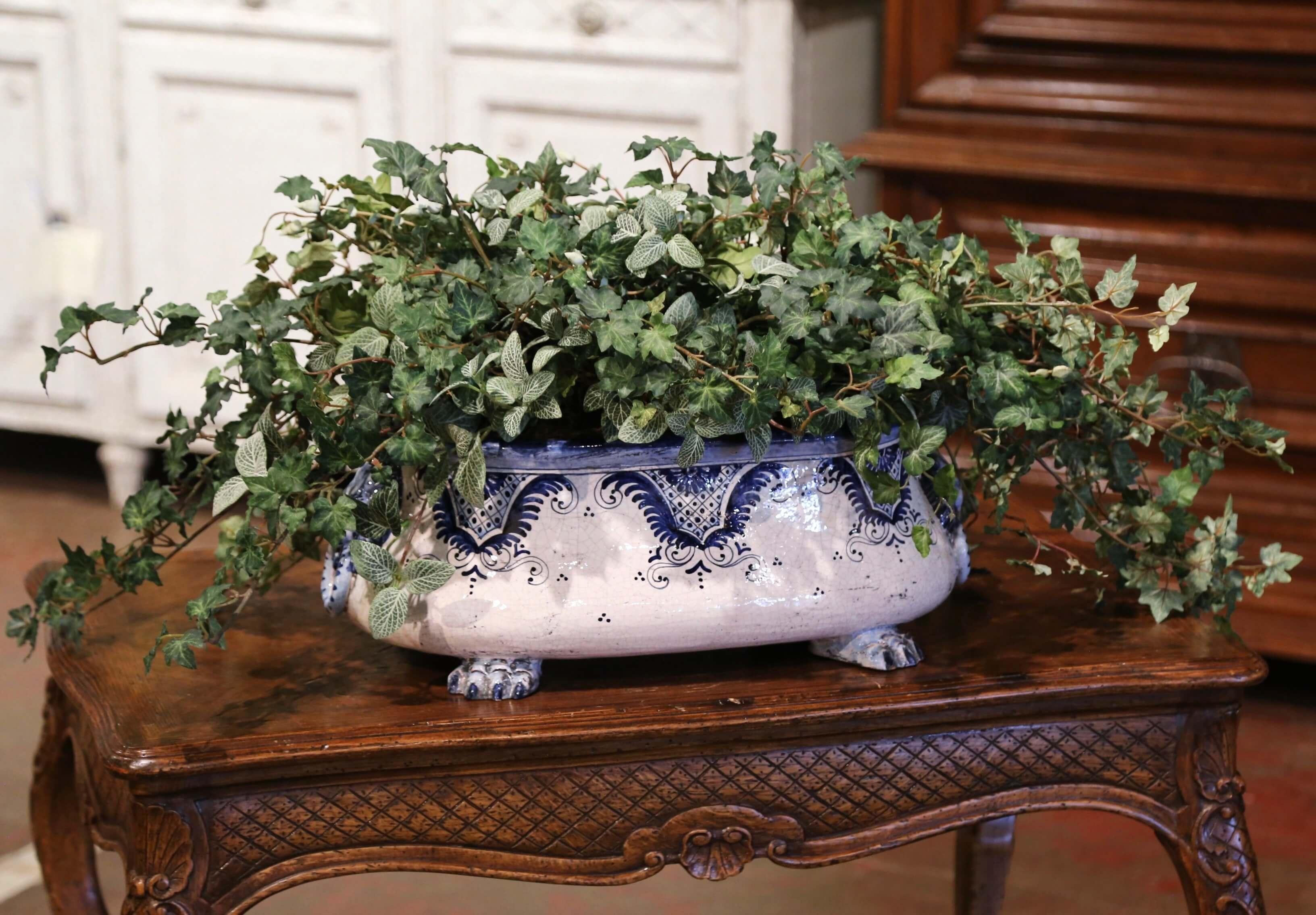 Decorate a buffet or dining table with this colorful ceramic cache pot. Crafted in Italy, circa 1960 and oval in shape, the jardinière stands on four paw feet and is dressed with lion head handles. The large faience planter is decorated with hand
