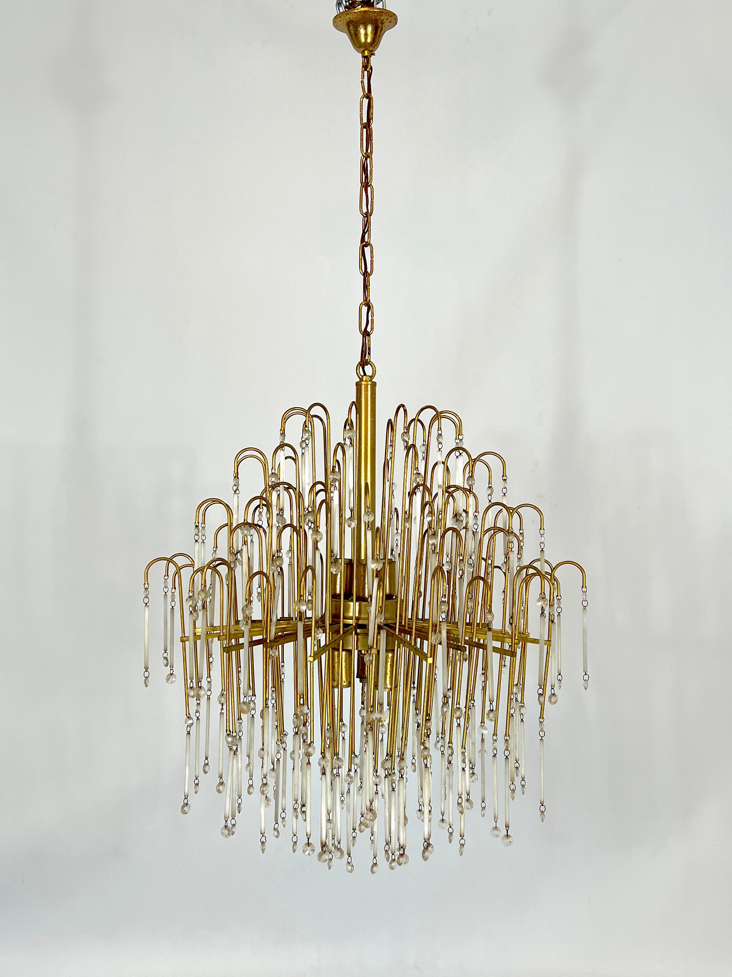Large brass and glass chandelier produced in Italy during the 70s. Good vintage condition with trace of age and use. Patina on the metal. Full working with EU standard, adaptable on demand for USA standard.