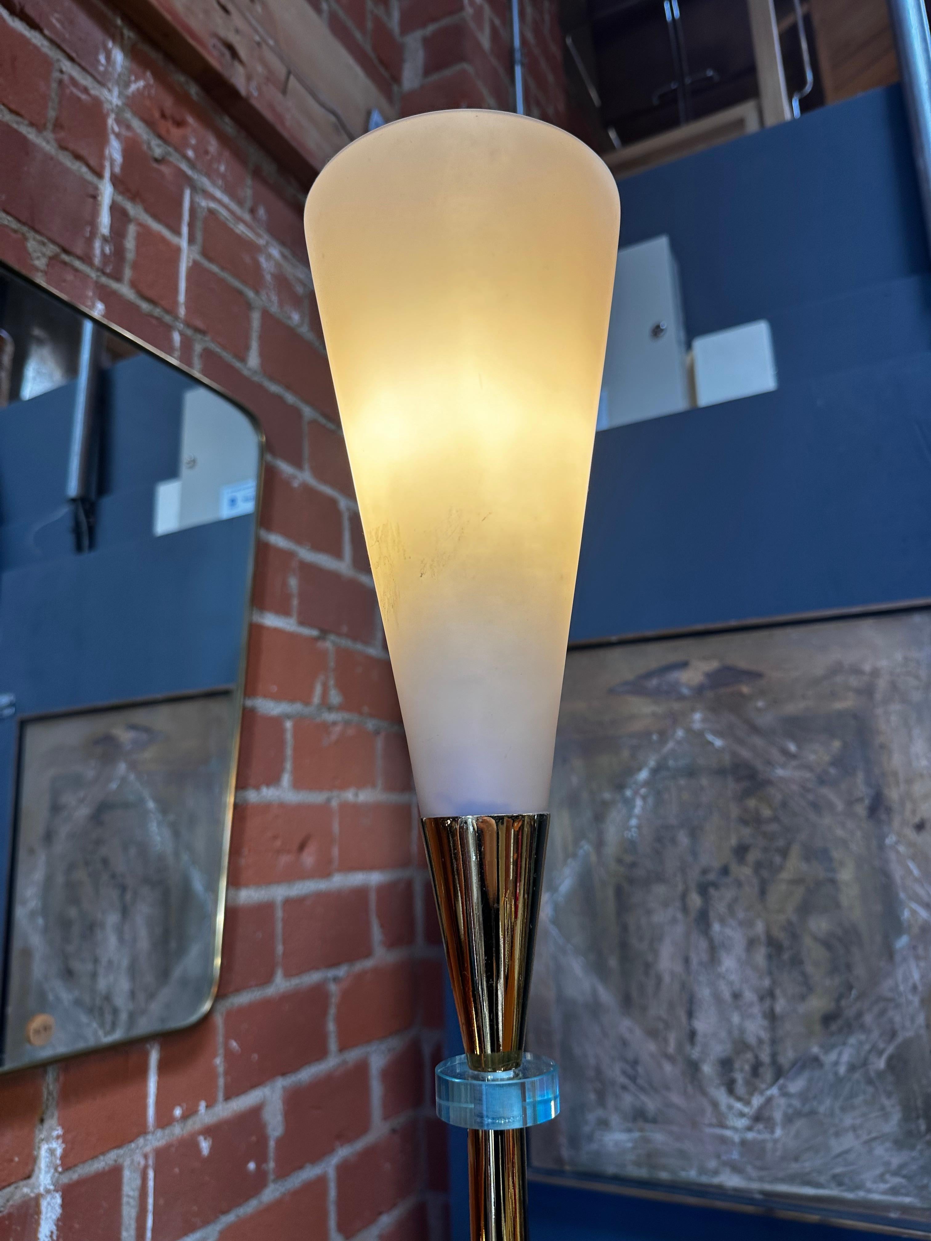 The Mid Century Italian Brass and Glass Floor Lamp from the 1960s is a sleek and sophisticated lighting fixture. Featuring a harmonious combination of brass and glass, this lamp exemplifies the elegant design trends of mid-century Italy. Its