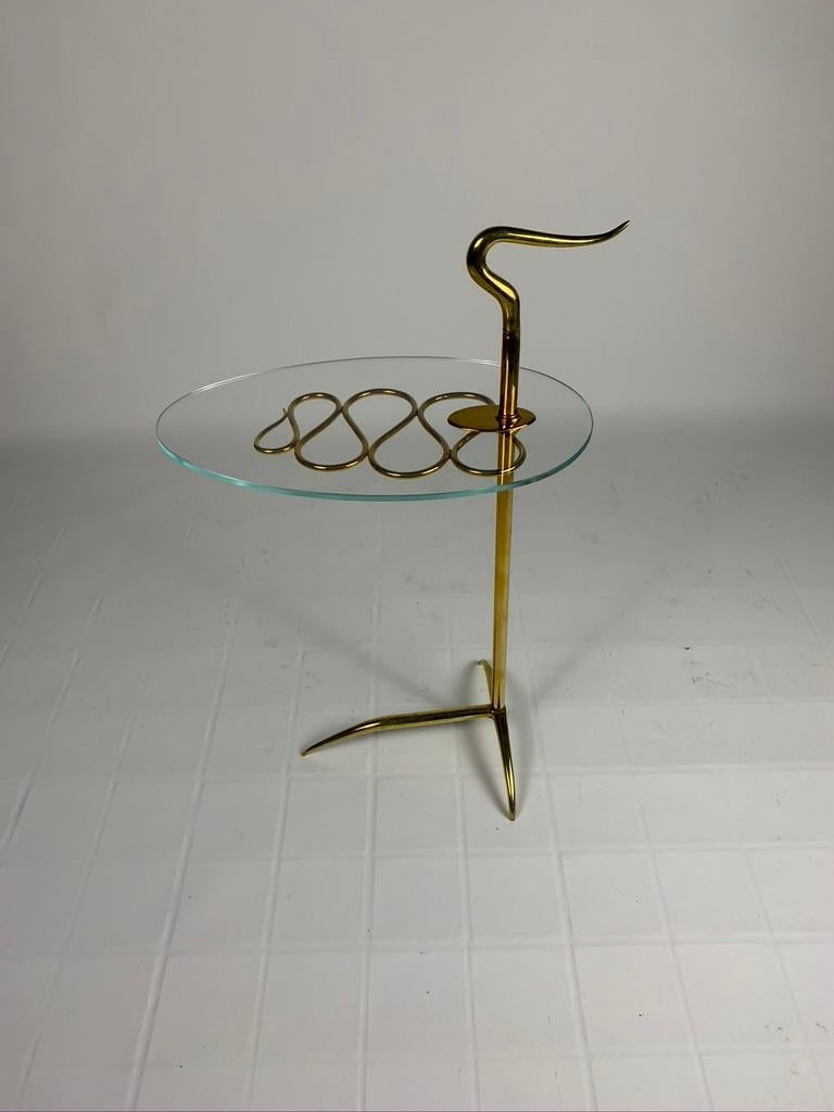Side serving table with casting brass structure, up there is a handle to be moved comfortably.
The glass top is supported by a whiplash decoration and the tripod base it is made up of slender and thin tapered legs.
Milan, Italy, 1950, Mid-Century