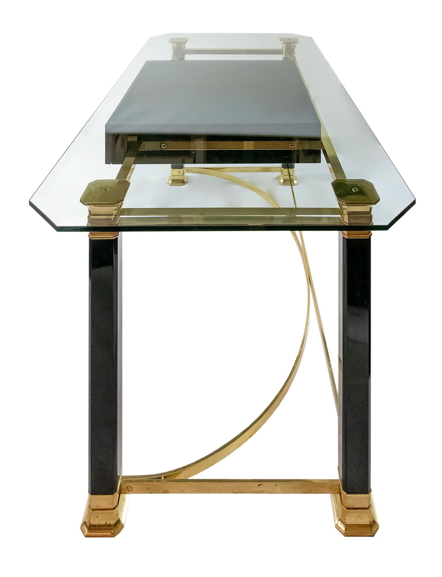 Midcentury Italian desk/writing table is made of brass and glass with one drawer.
The brass is polished and part of legs are in black color varnished finish.
The glass top is thick, faceted and very heavy.
Signed made in Italy.